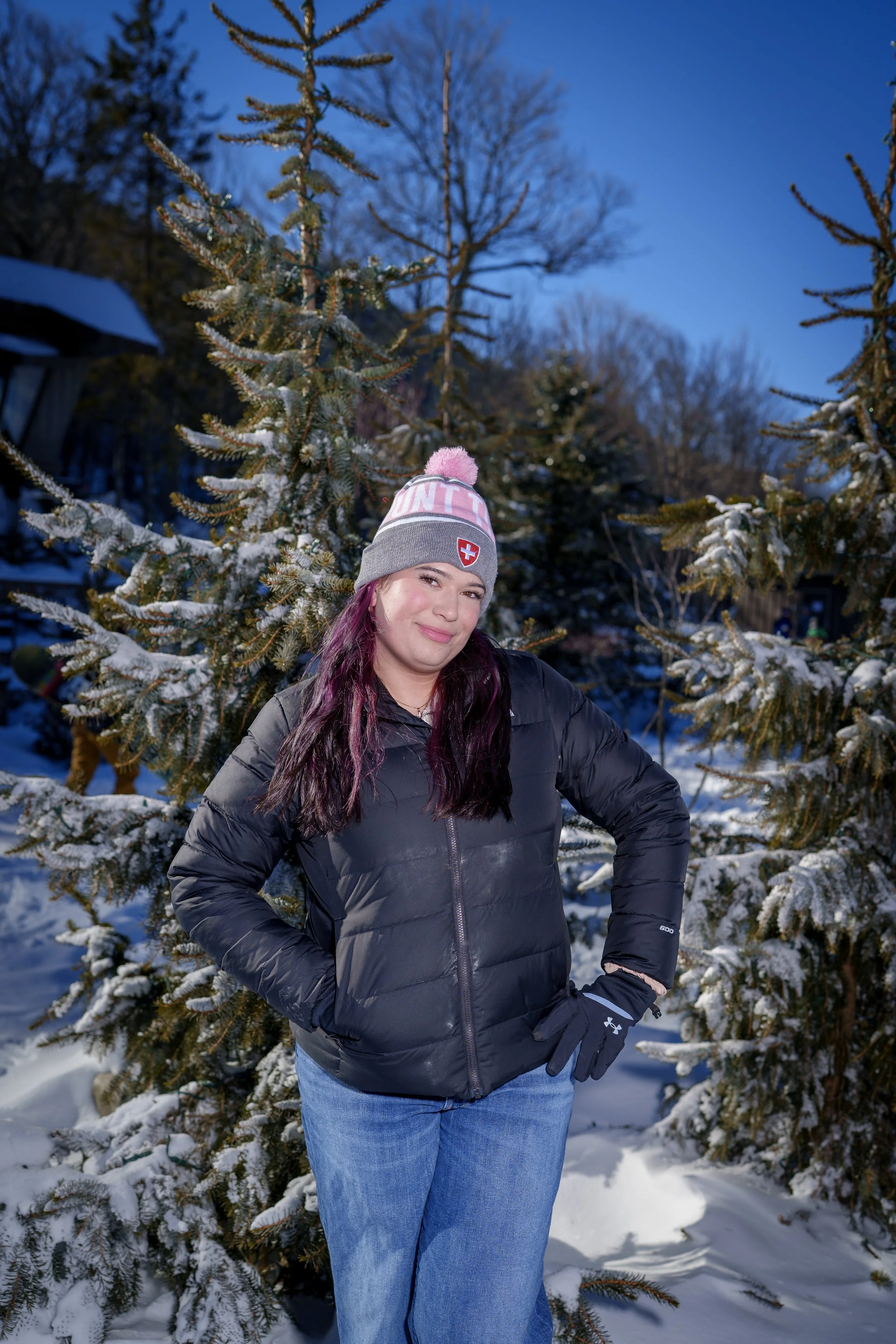 Teenage girl in a winter hat among snow-covered pines, winter portrait photographer Fort Mill SC
