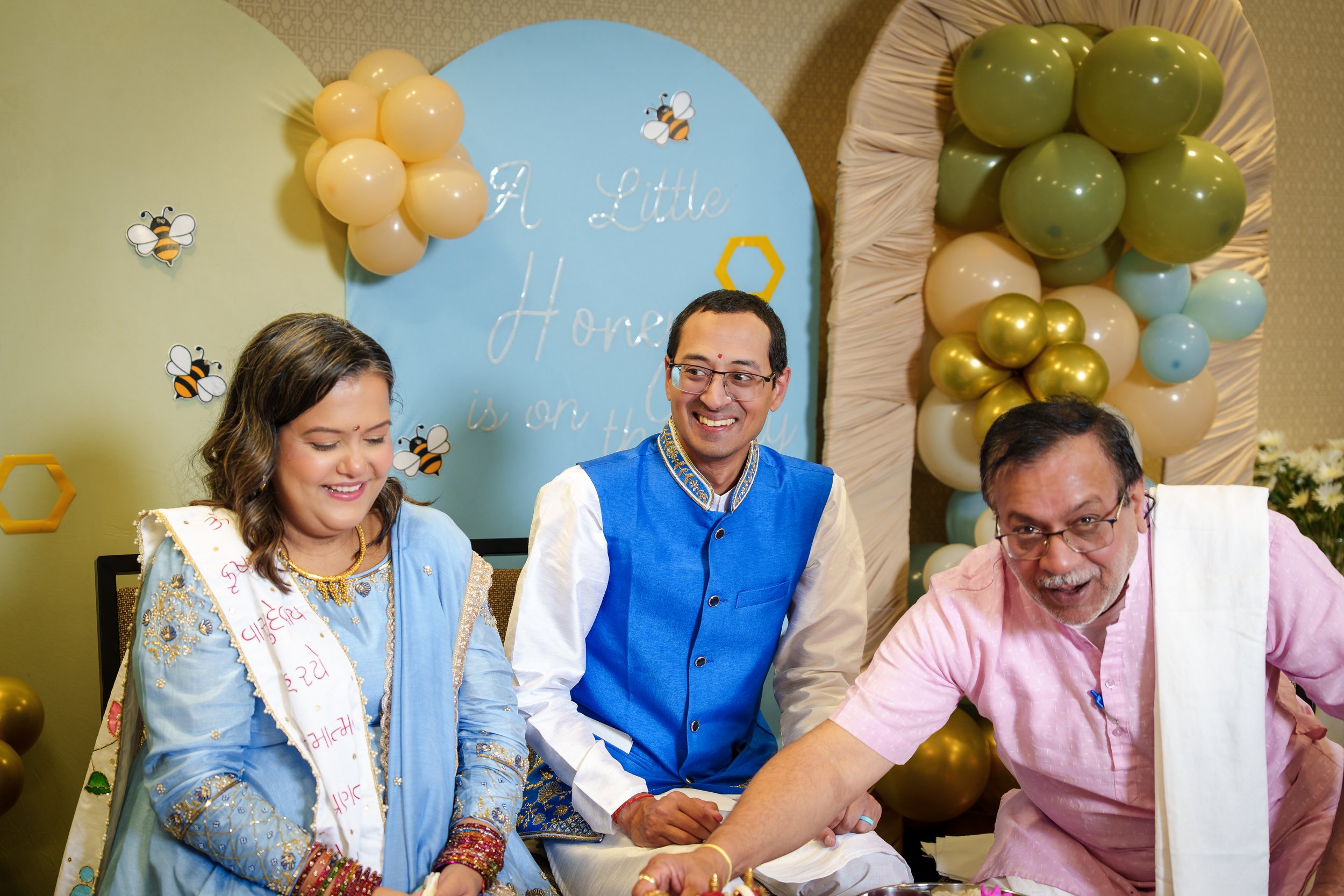 Baby shower ceremony photography in Fort Mill, SC — an expectant couple seated together, both smiling, as the officiant reaches across the tray in front of them.