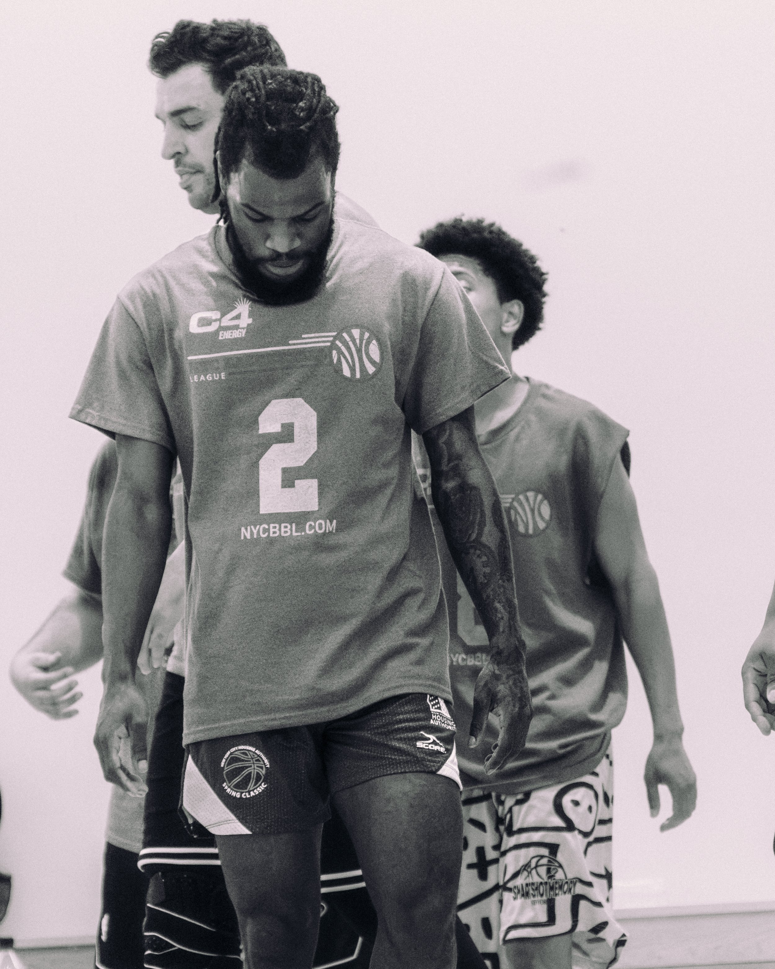 Drei Basketballspieler in einem Training oder Spiel, die sich auf einem Basketballfeld befinden, getragen in Sportkleidung.