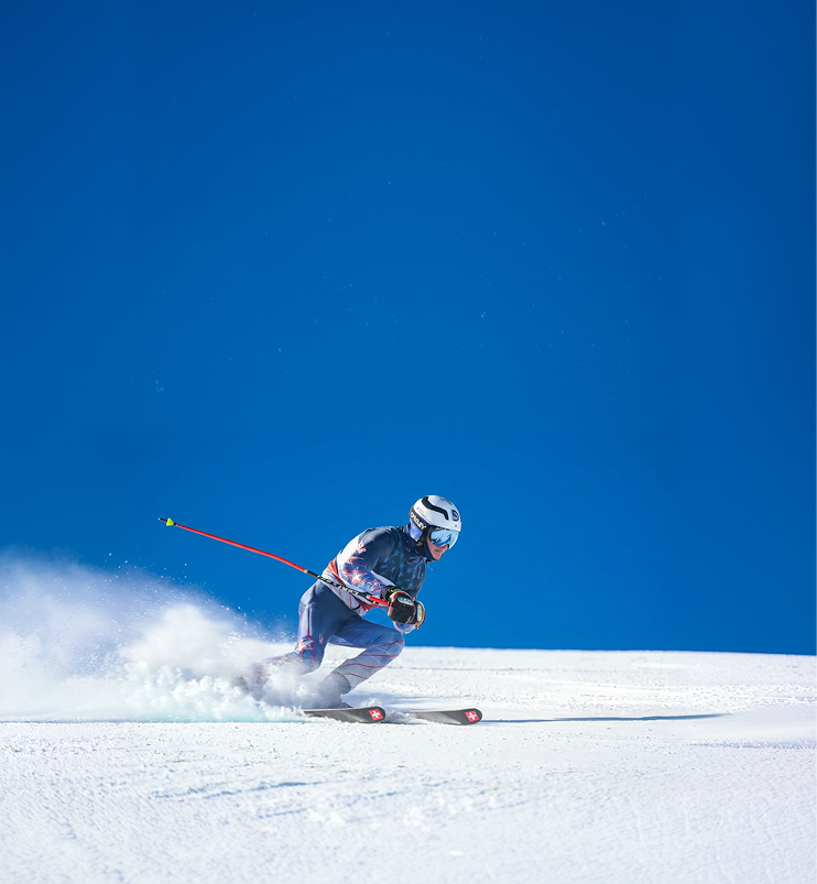 Para-alpine skier racing down a snow-covered slope.