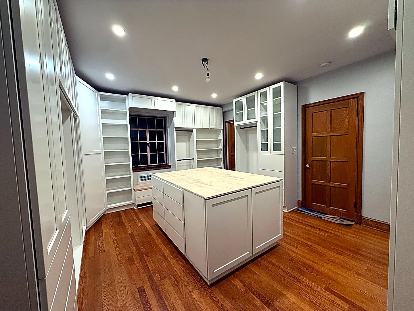 White kitchen with floor-to-ceiling built-in cabinetry and a freestanding island