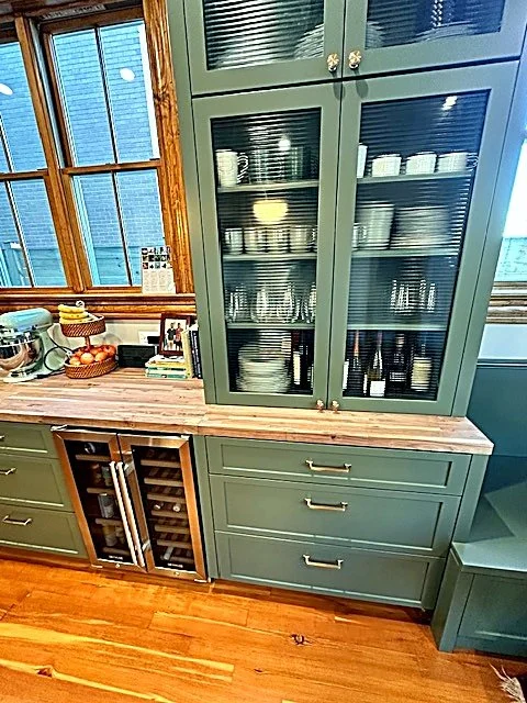 Teal glass-front hutch with a butcher-block counter and built-in wine fridge