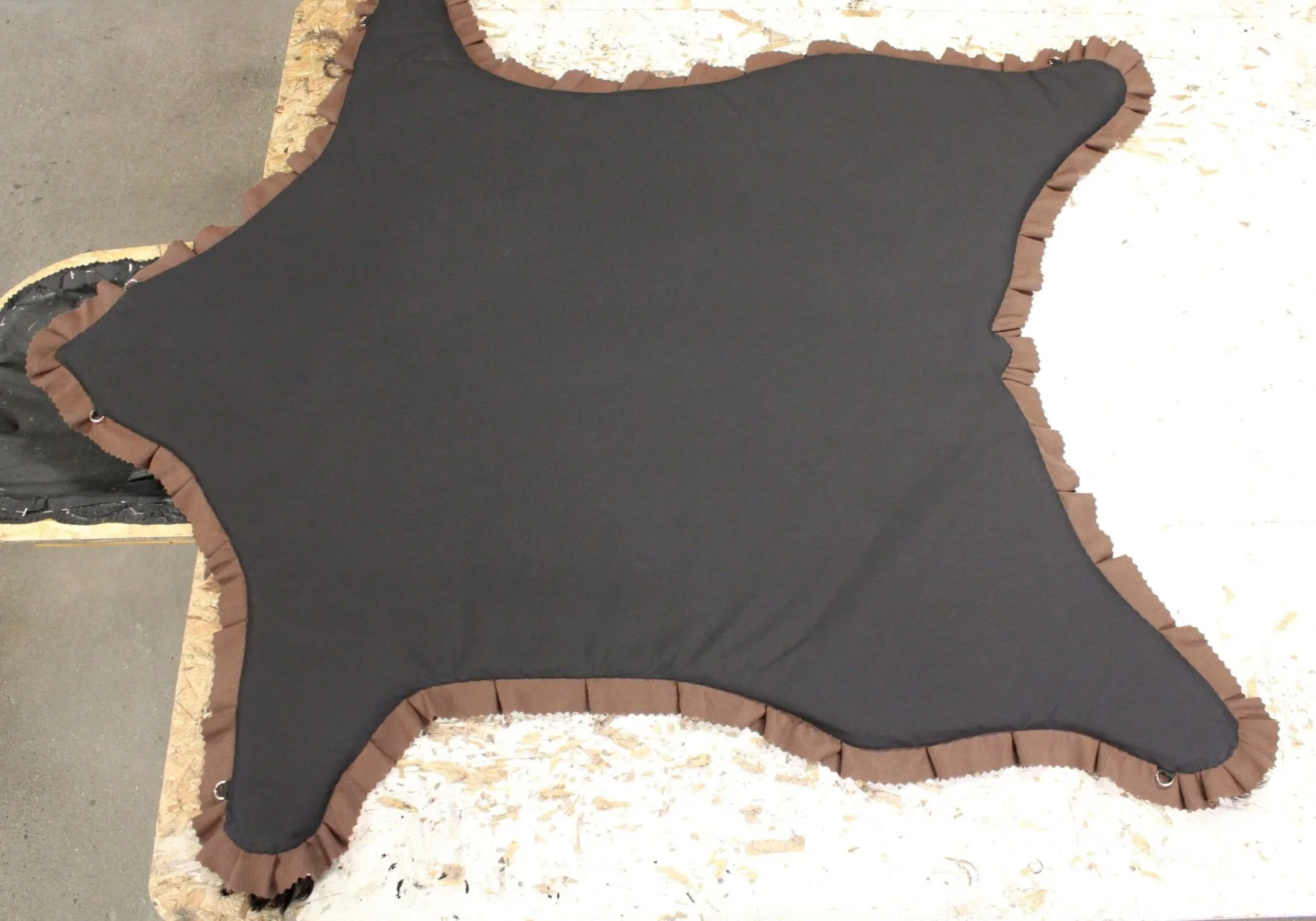 The back side of a standard rug, show casing backing and d-rings. 