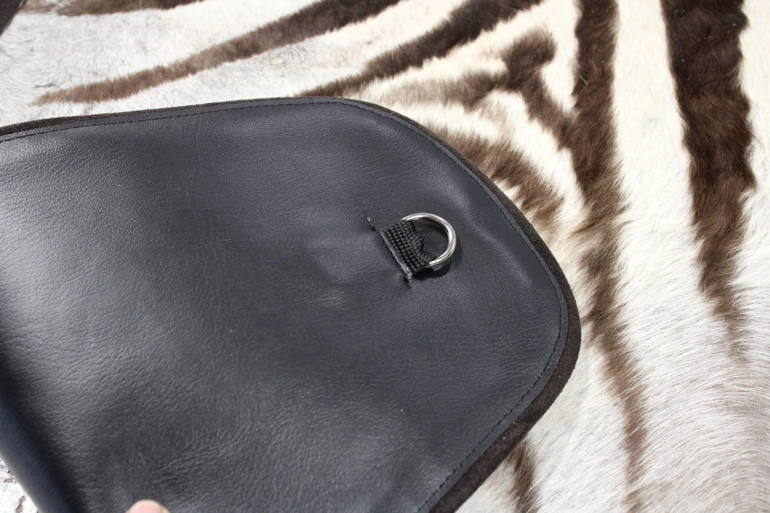 Close-up of the vinyl and d-ring on the back side of a standard flat rug. 