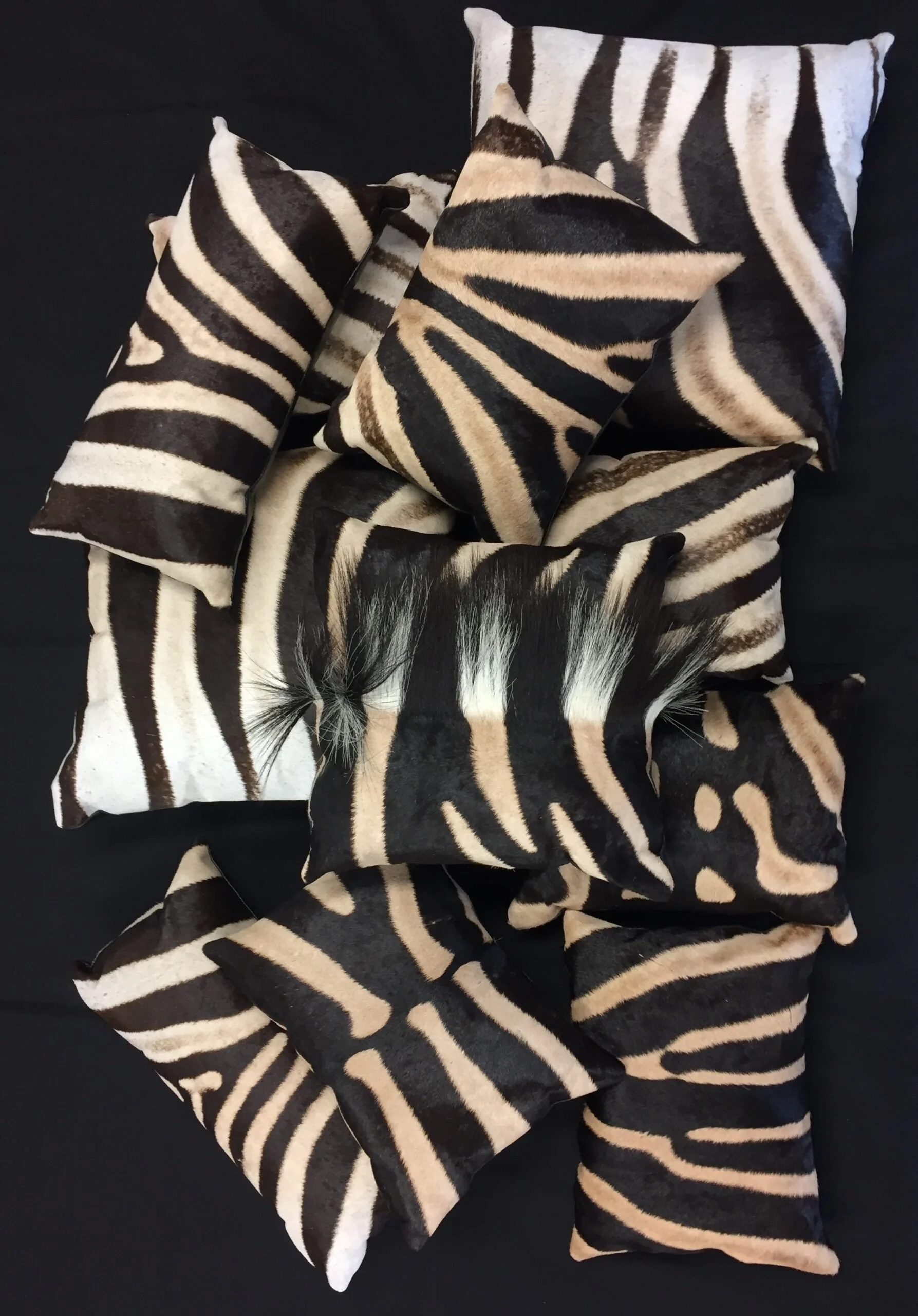 Set of pillows with zebra print on a black background.