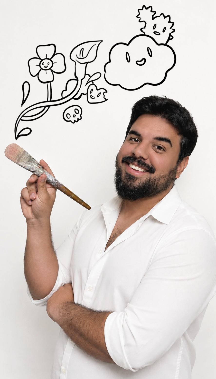 A man with dark hair and a beard smiling, holding a paintbrush, with illustrations of a flower character with a smile, twisting vines and leaves, a small bubbly skull, and a happy smiling cloud drawn on a white wall behind him.