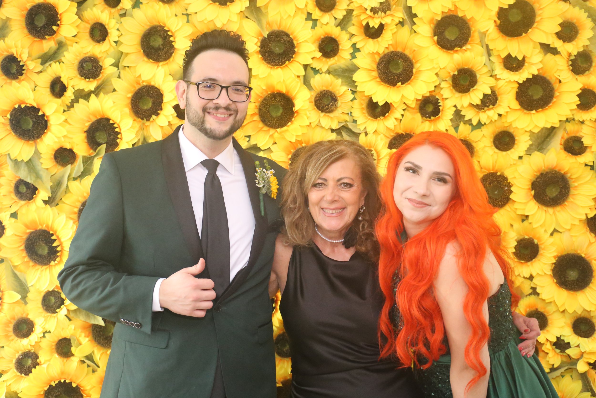 clara with clients at event in front of sunflower wall.JPG