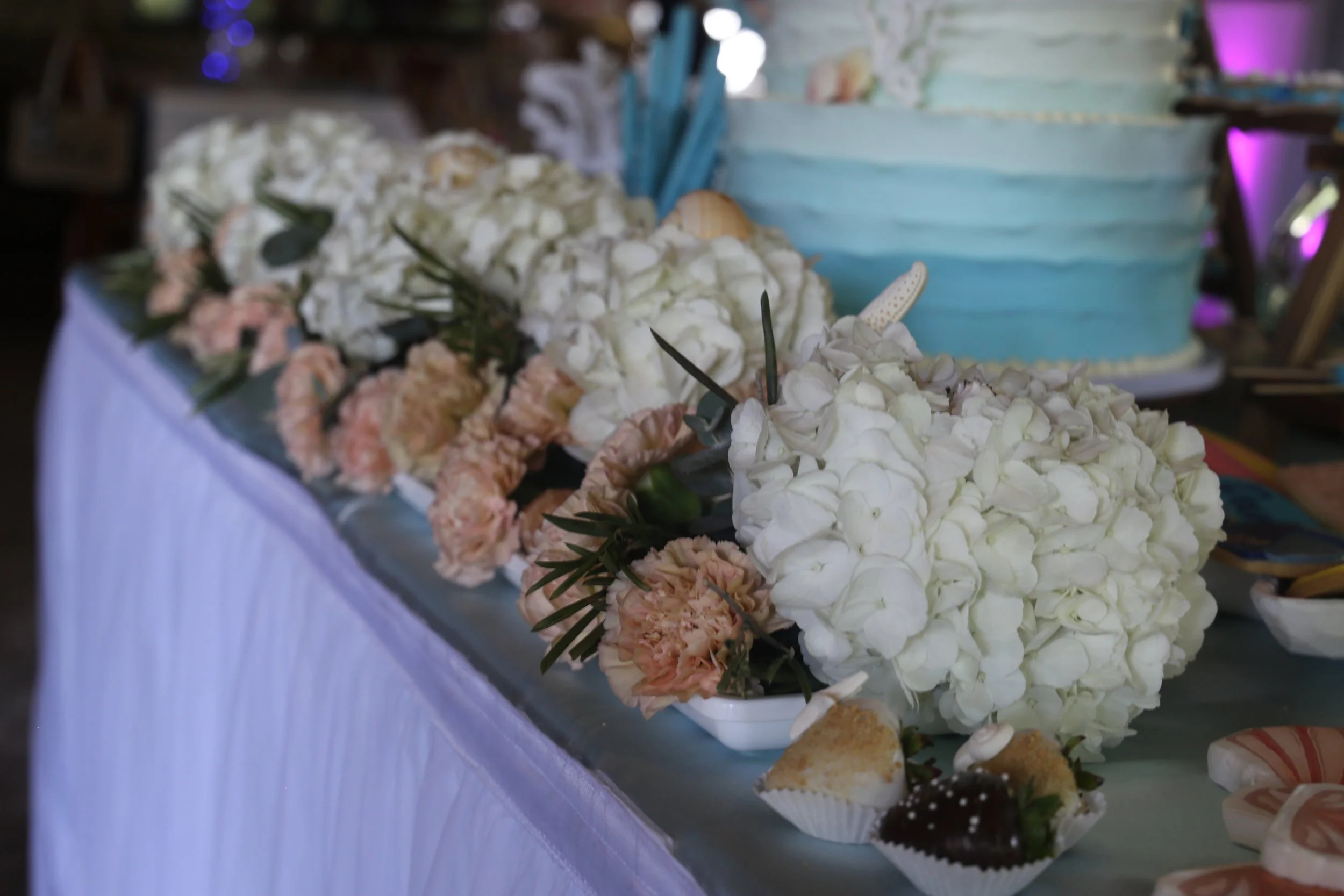 flowers on a beach themed cake table.JPG