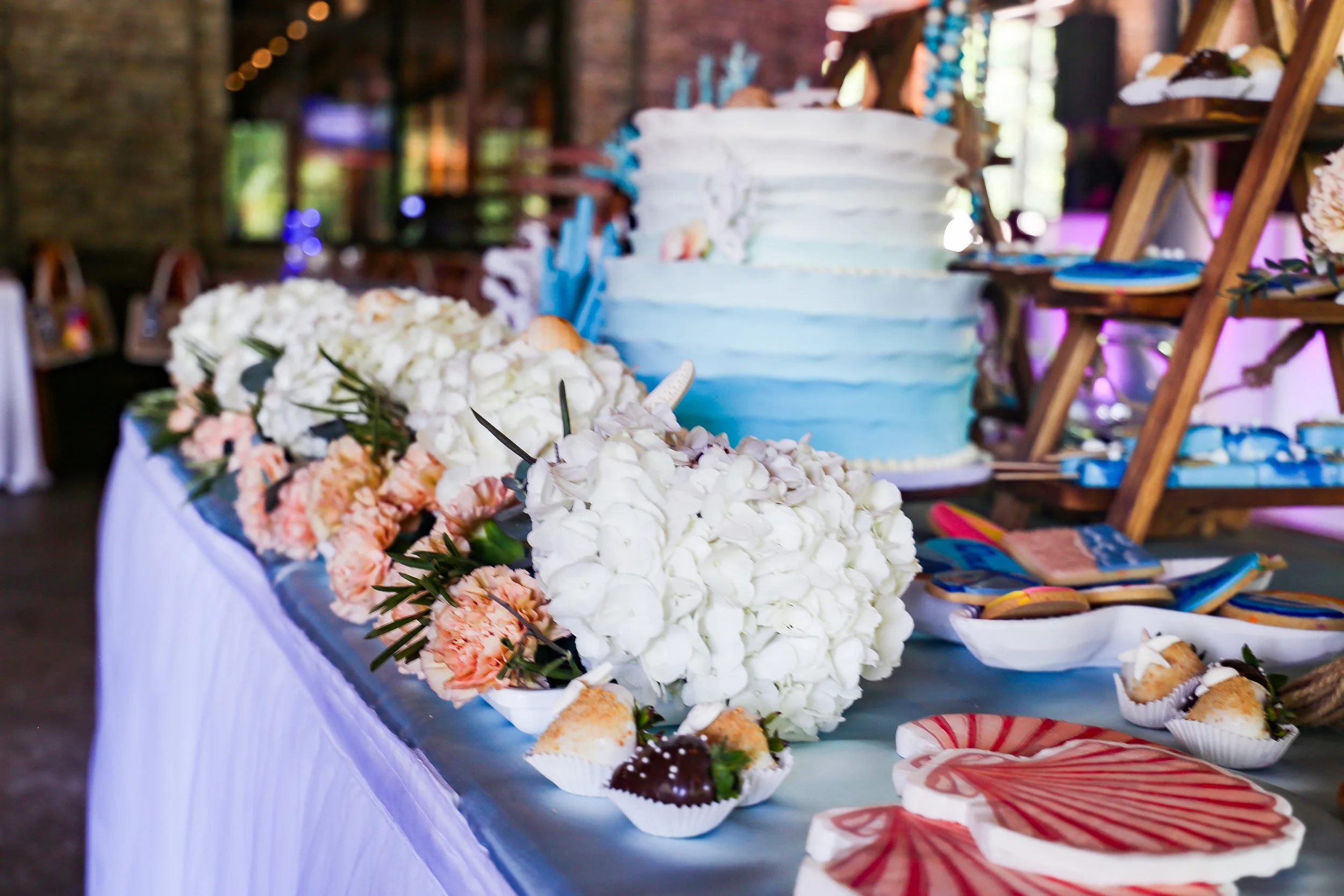 coastal themed cake table at event with white flowers
