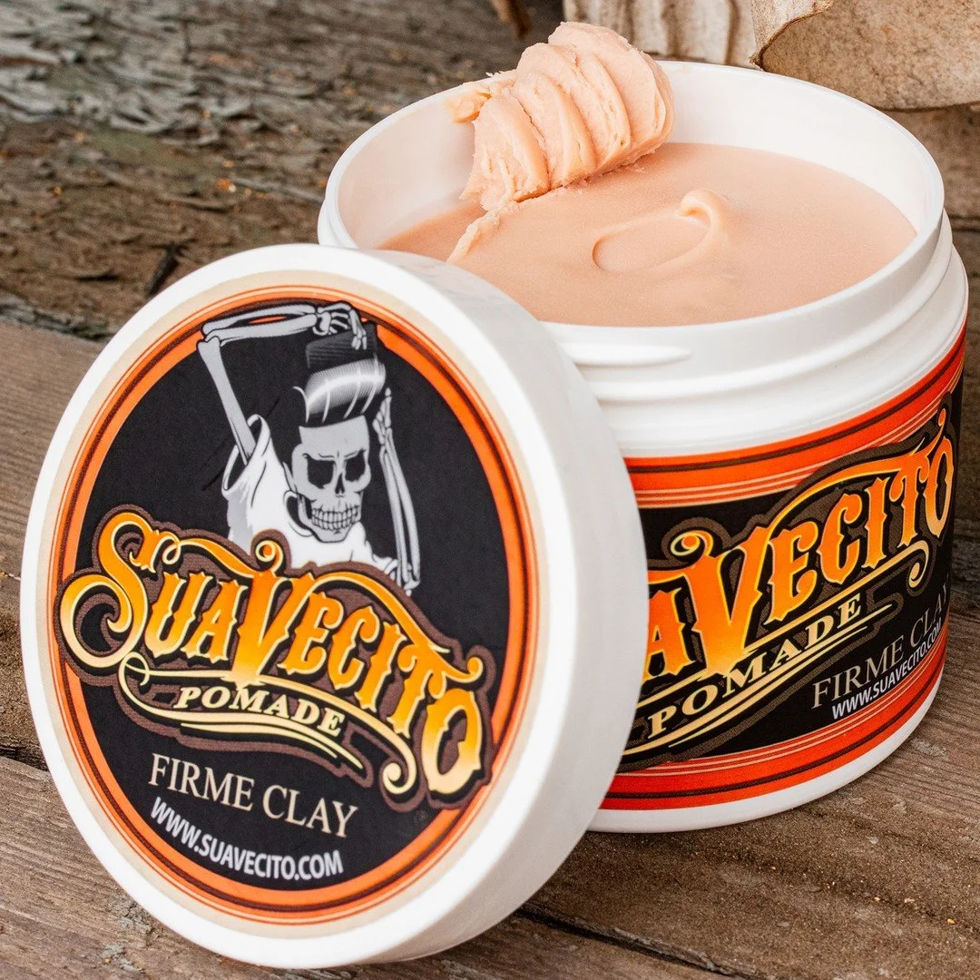 Open container of Suavecito Pomade Firme Clay with a slice of peach