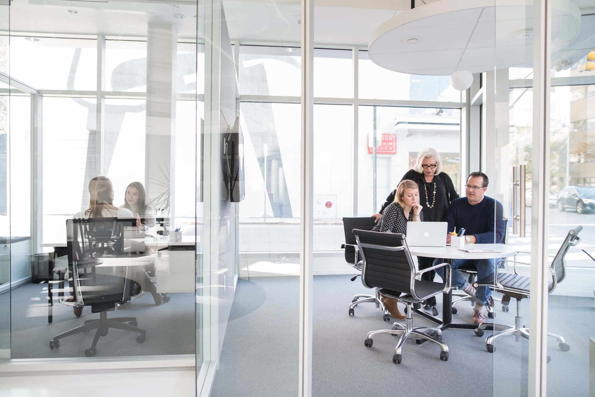 Compass real estate agents meeting with clients in a bright, modern office