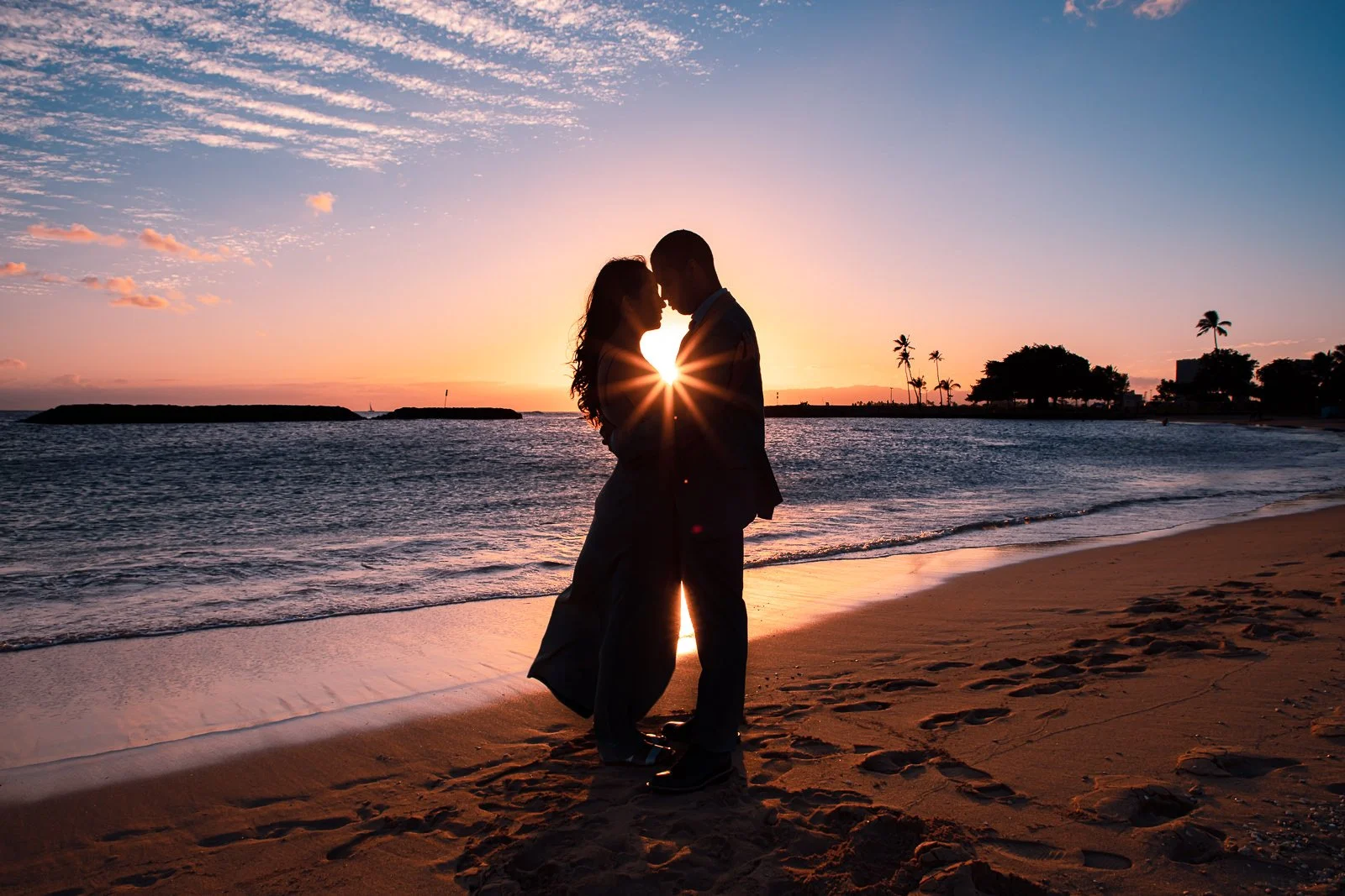 couple hugging at sunset sun burst engagement photos