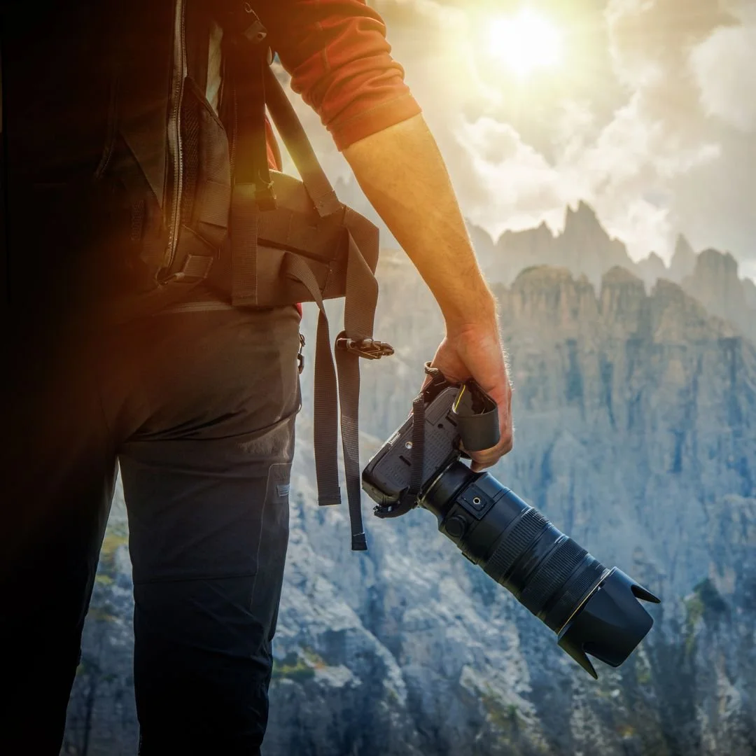 man with camera in mountains as family photographer