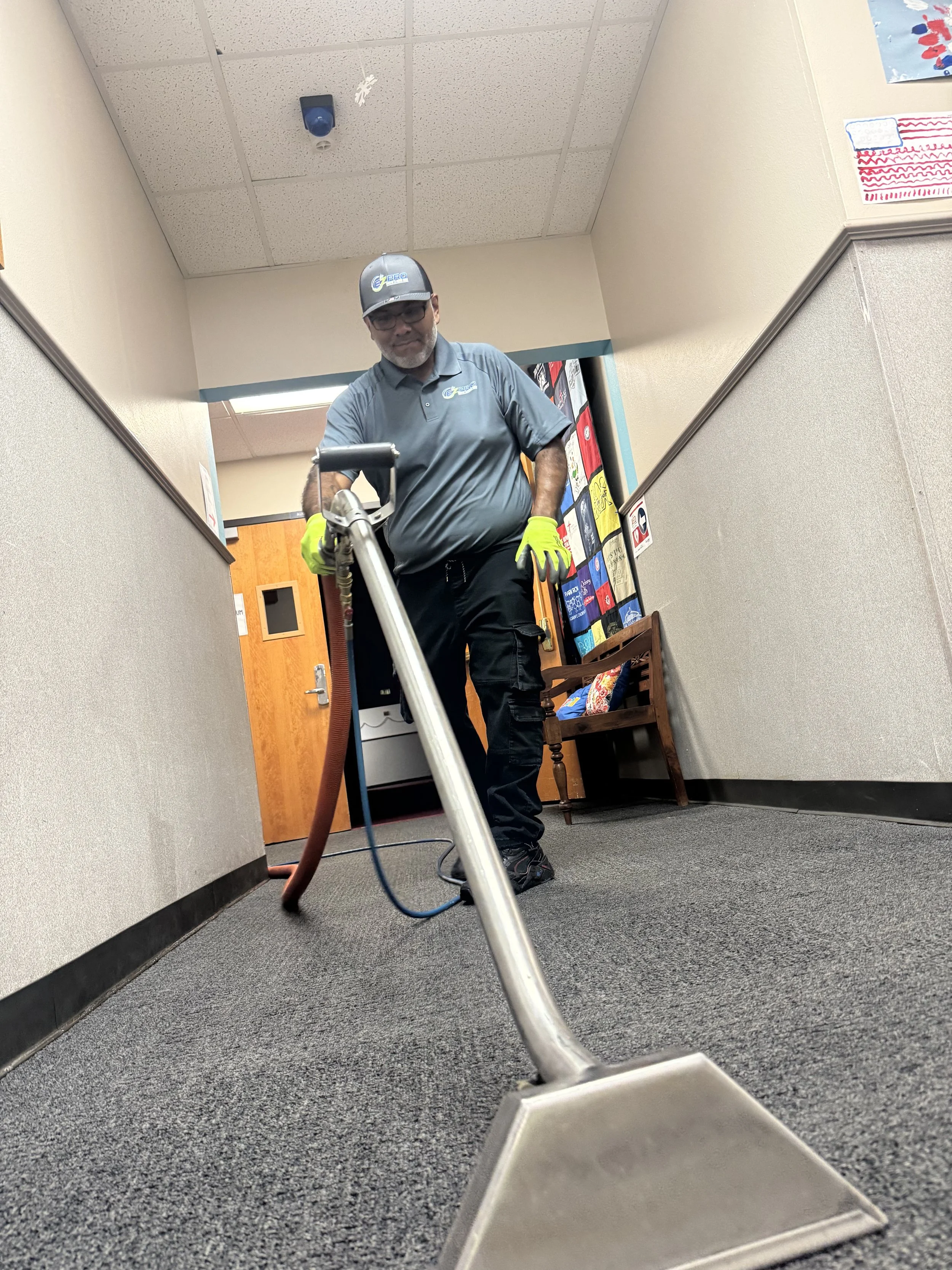 "EZ PRO technician providing commercial carpet cleaning, vacuuming and maintenance for DFW office building."