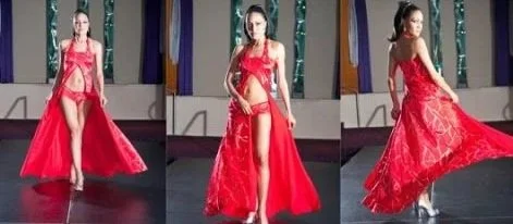 Model walking on runway in a red bridal gown with lace details.