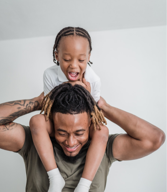 Father carrying his smiling son on his shoulders
