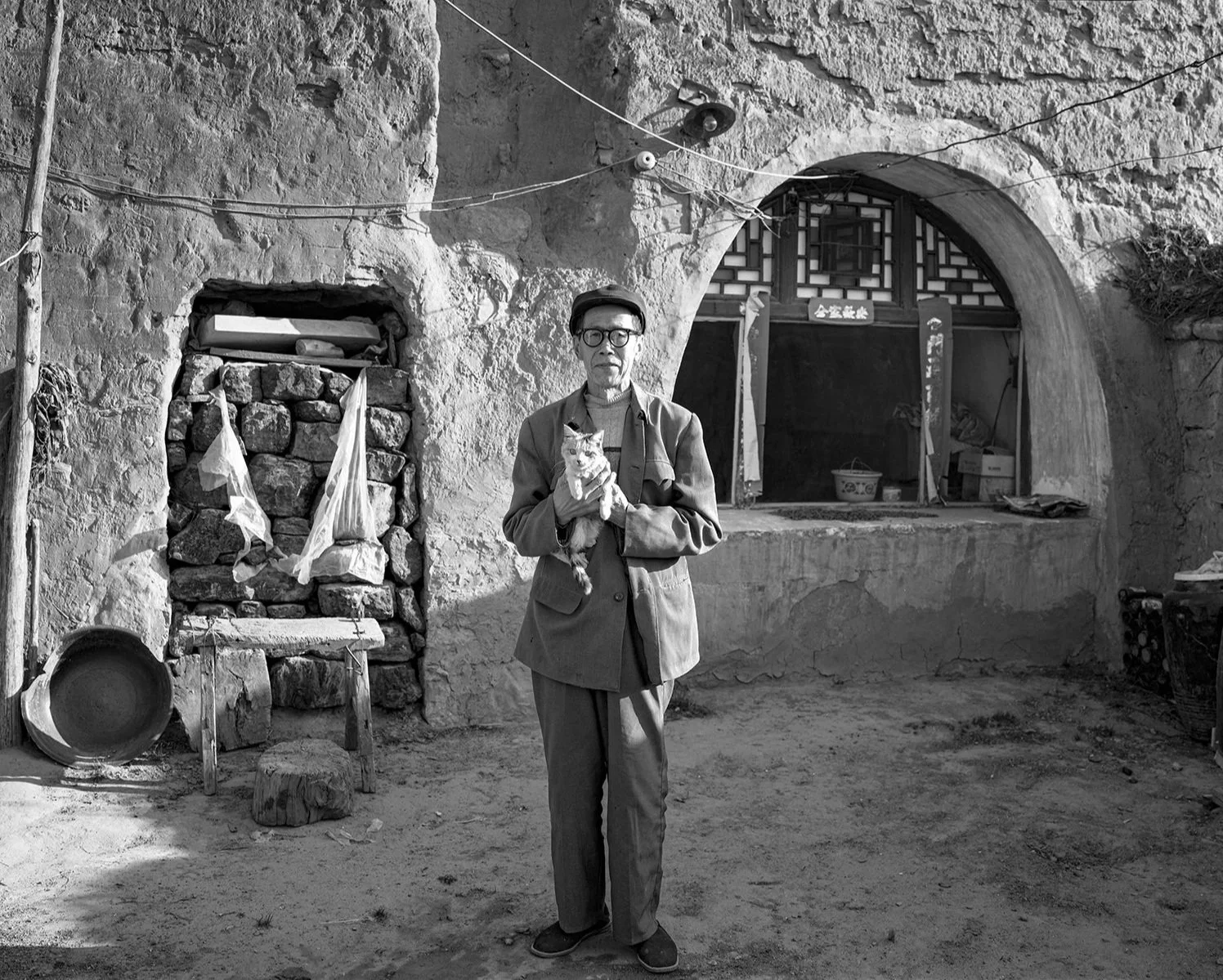 An elderly man with his cat, Laoyingbao, Pianguan, Shanxi, 2009