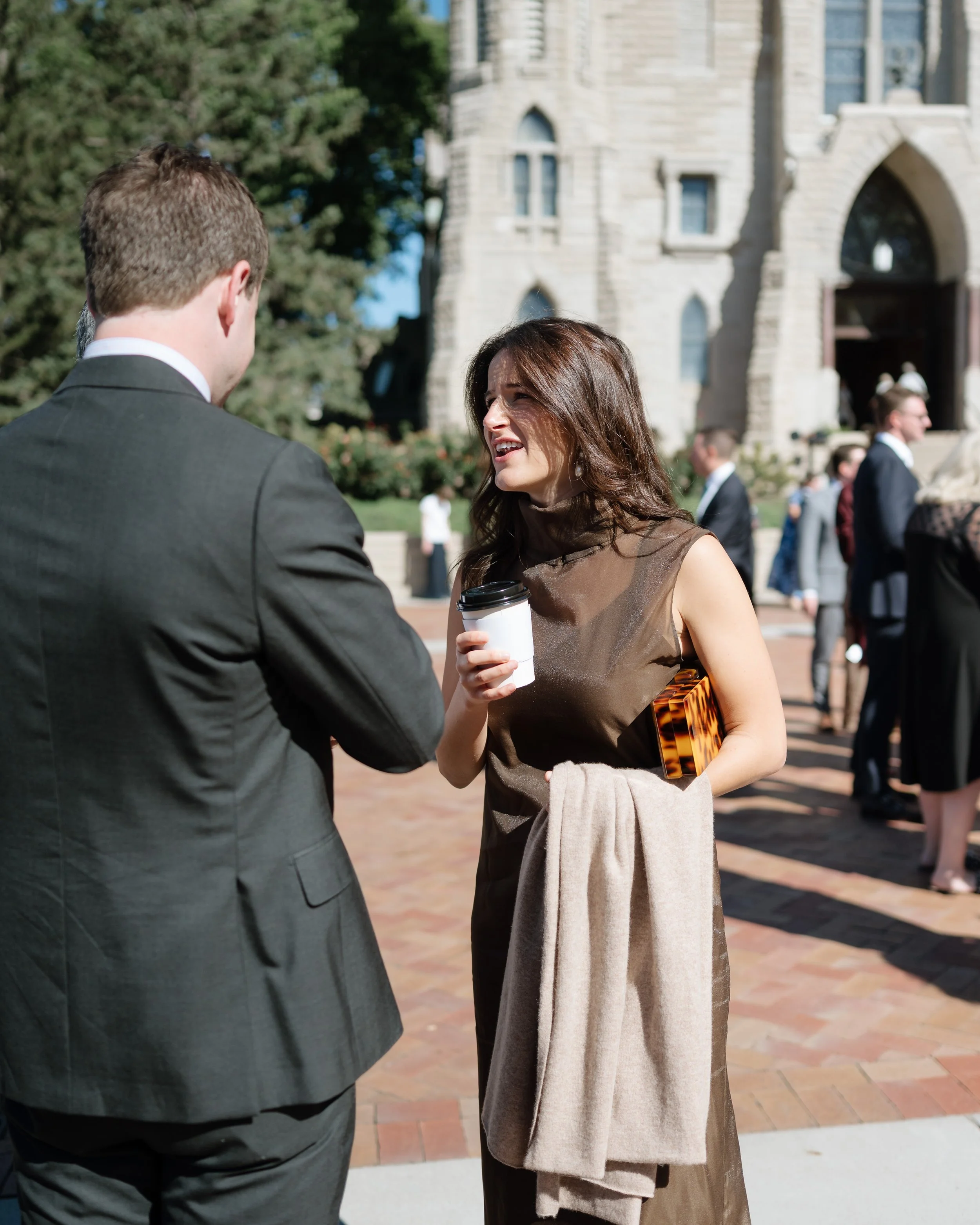 Guests sharing a laugh over freshly made coffee at an outdoor celebration.