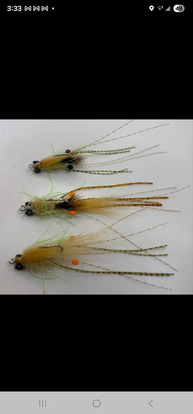 Three handcrafted fishing lures with feathers, beads, and synthetic materials arranged on a white background.