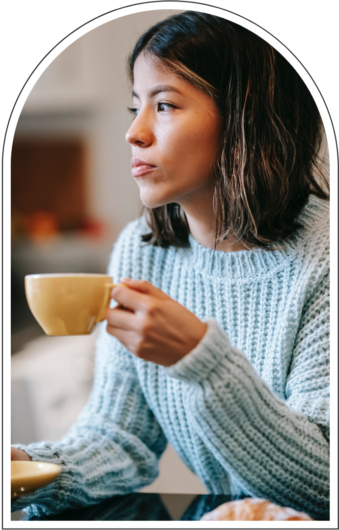 Woman in a light blue sweater holding a yellow cup of coffee