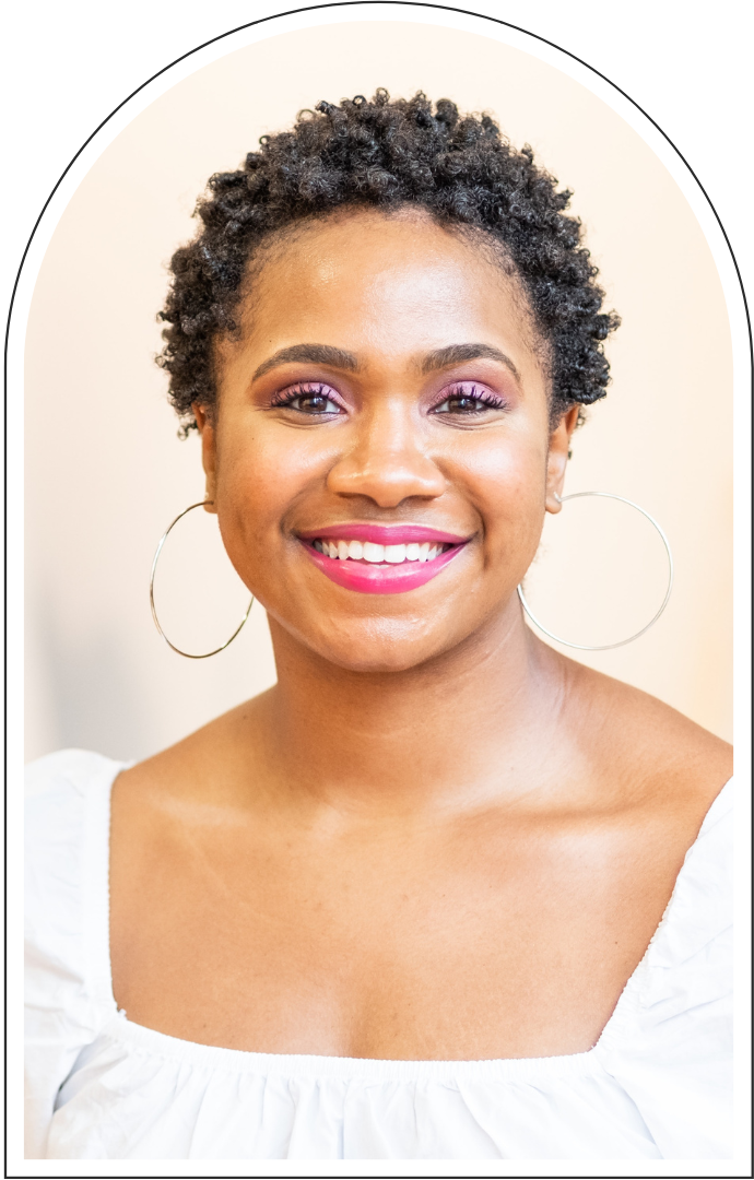 Smiling Black woman with short natural curls, hoop earrings, pink makeup, and a white off-shoulder top