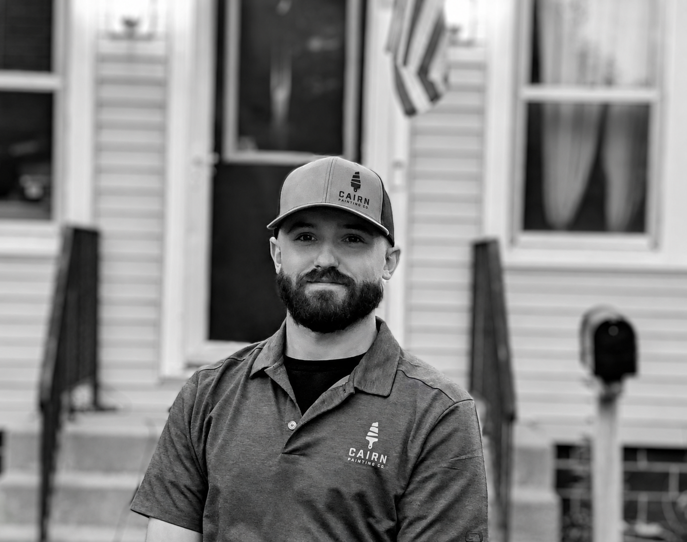Cairn Painting Co. crew member standing in front of a freshly painted home