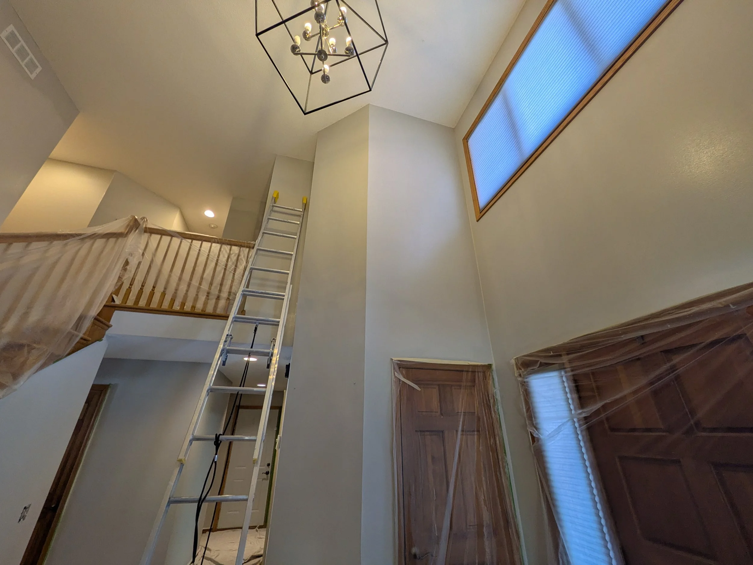 Interior painting in progress on a two-story entryway by Cairn Painting Co.