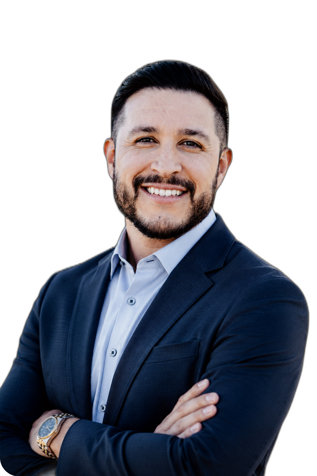 A smiling man in a navy blue suit with a white shirt, standing with arms crossed against a black background.
