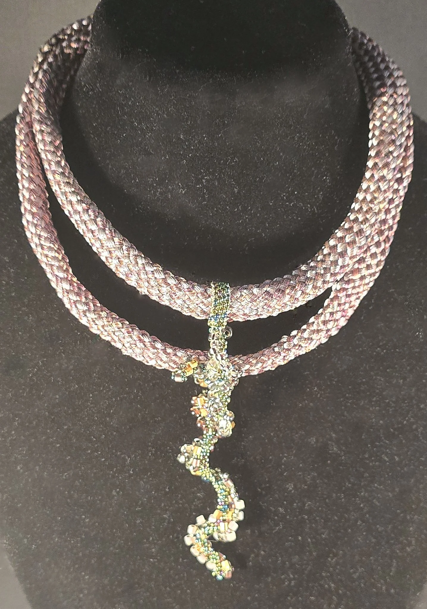 Liminal

Liminal is a one-of-one wearable work rooted in the ancient Japanese braiding practice of Kumihimo. Two hollow Kumihimo braids, constructed on a marudai using Japanese threads hand-dipped in metallics, create a layered structure that moves a