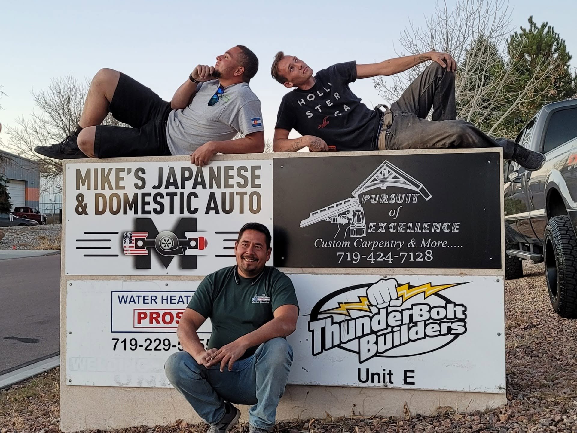 Pursuit of Excellence team members are installing a company sign in Colorado Springs.