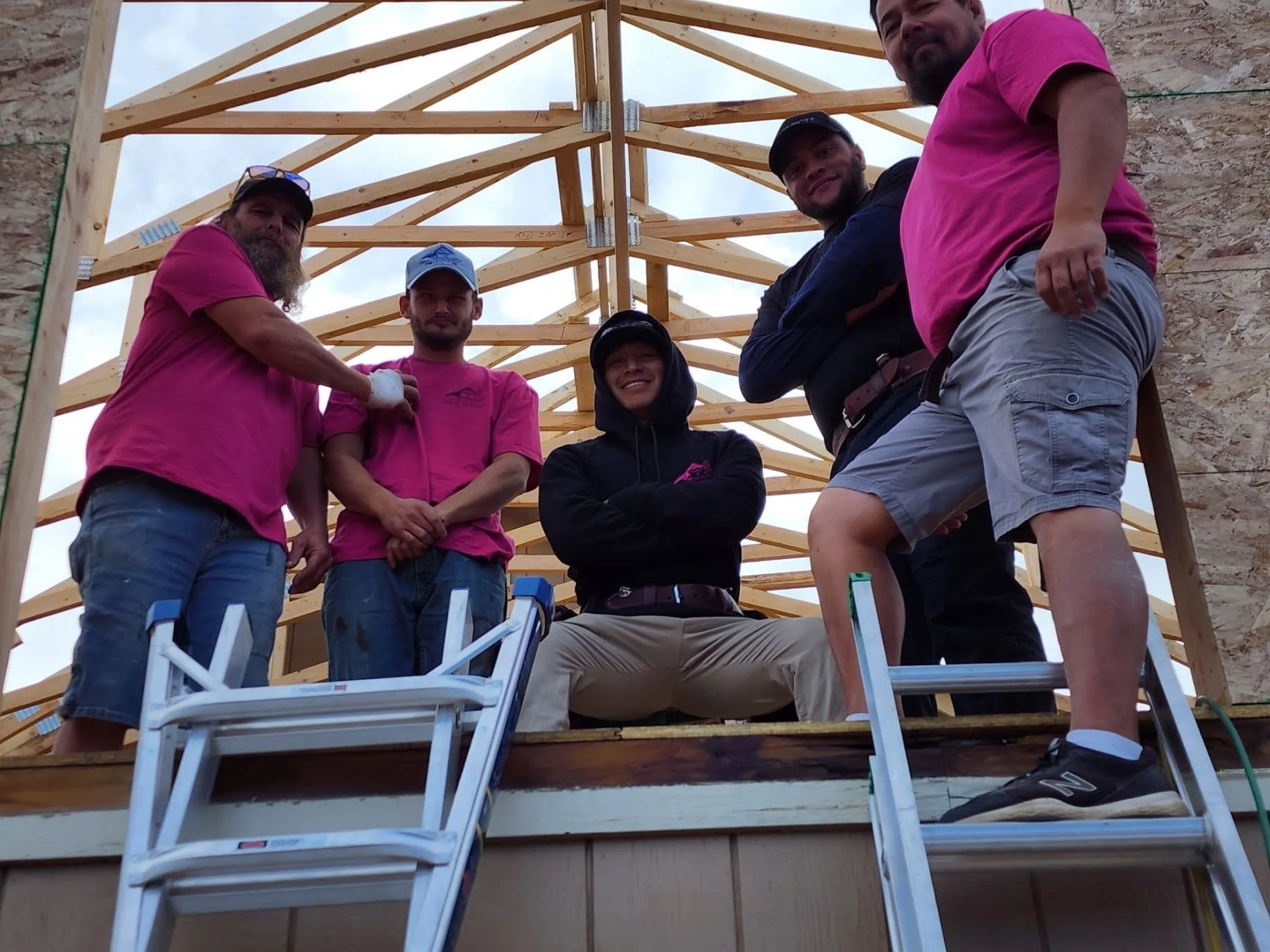 Pursuit of Excellence construction team gathered on a covered porch during the building process.