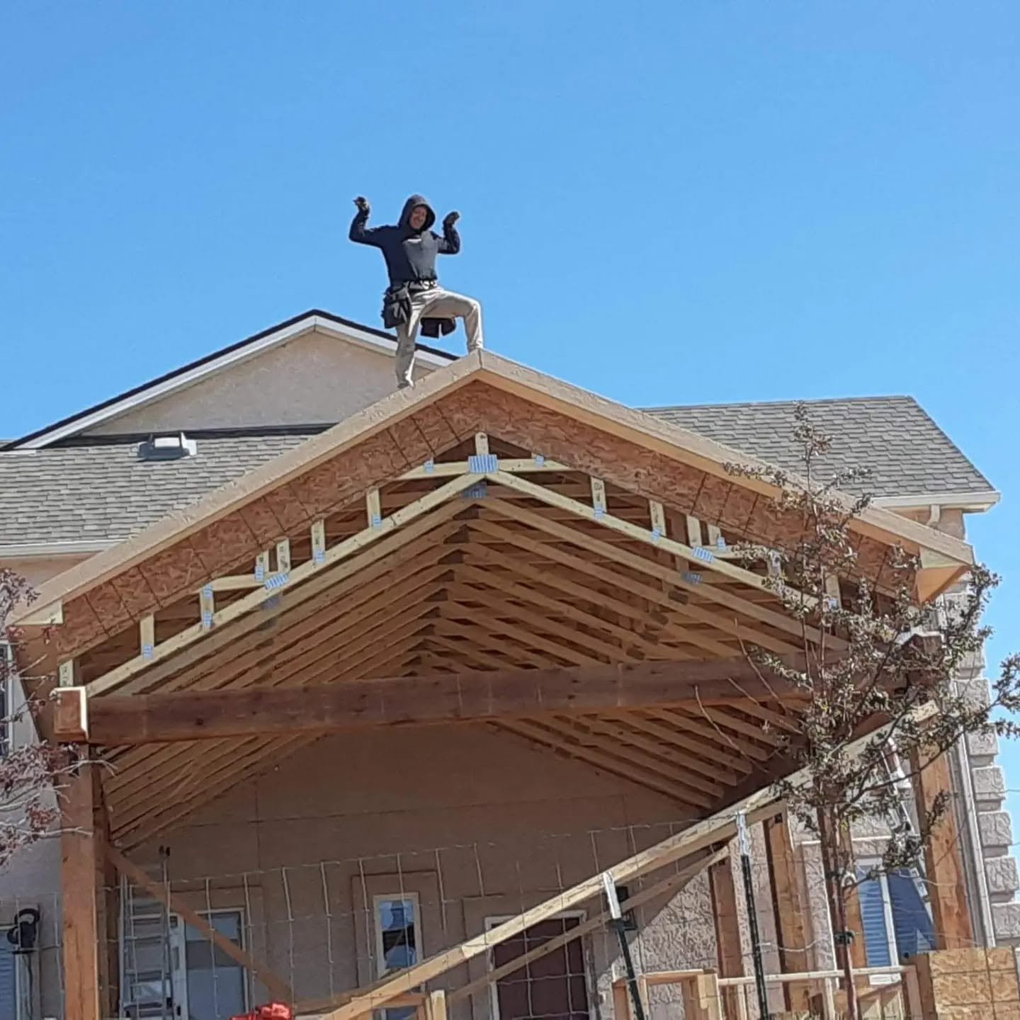 Pursuit of Excellence team member working on the roof of a home under construction.