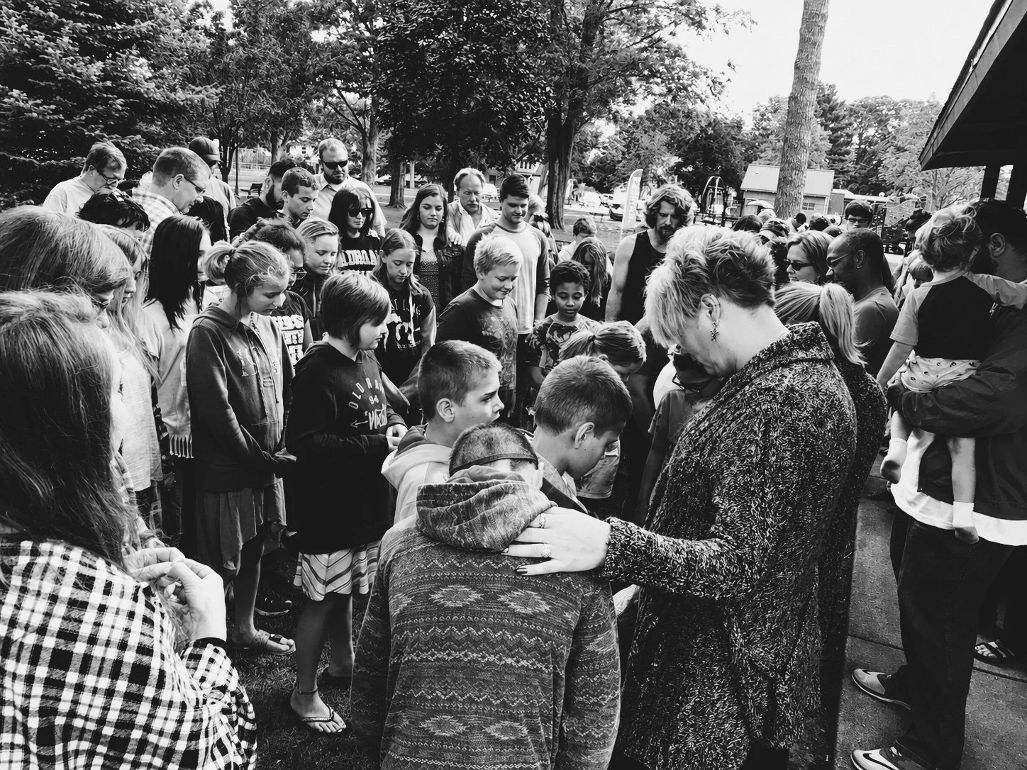 New Life Church praying with people during an outdoor community gathering at Wayland City Park