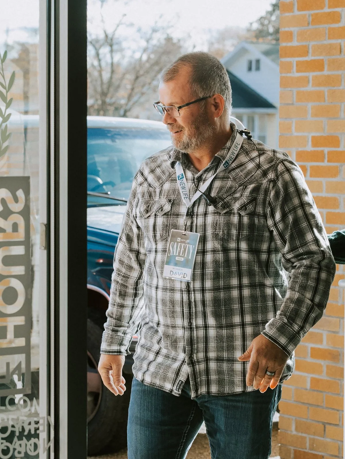 A New Life Church hospitality volunteer welcoming people at the entrance