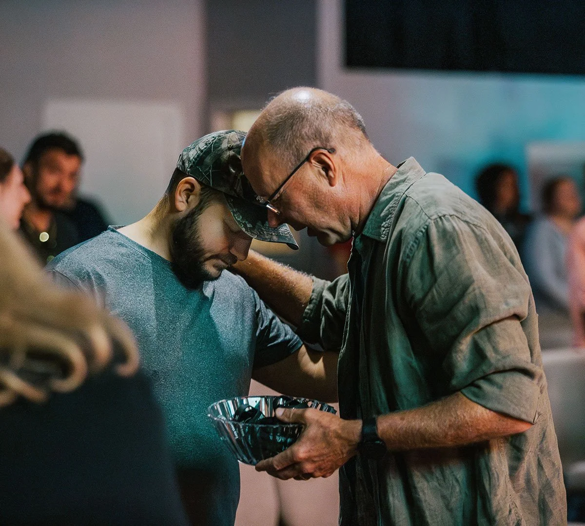A New Life Church leader praying with someone taking a step of faith