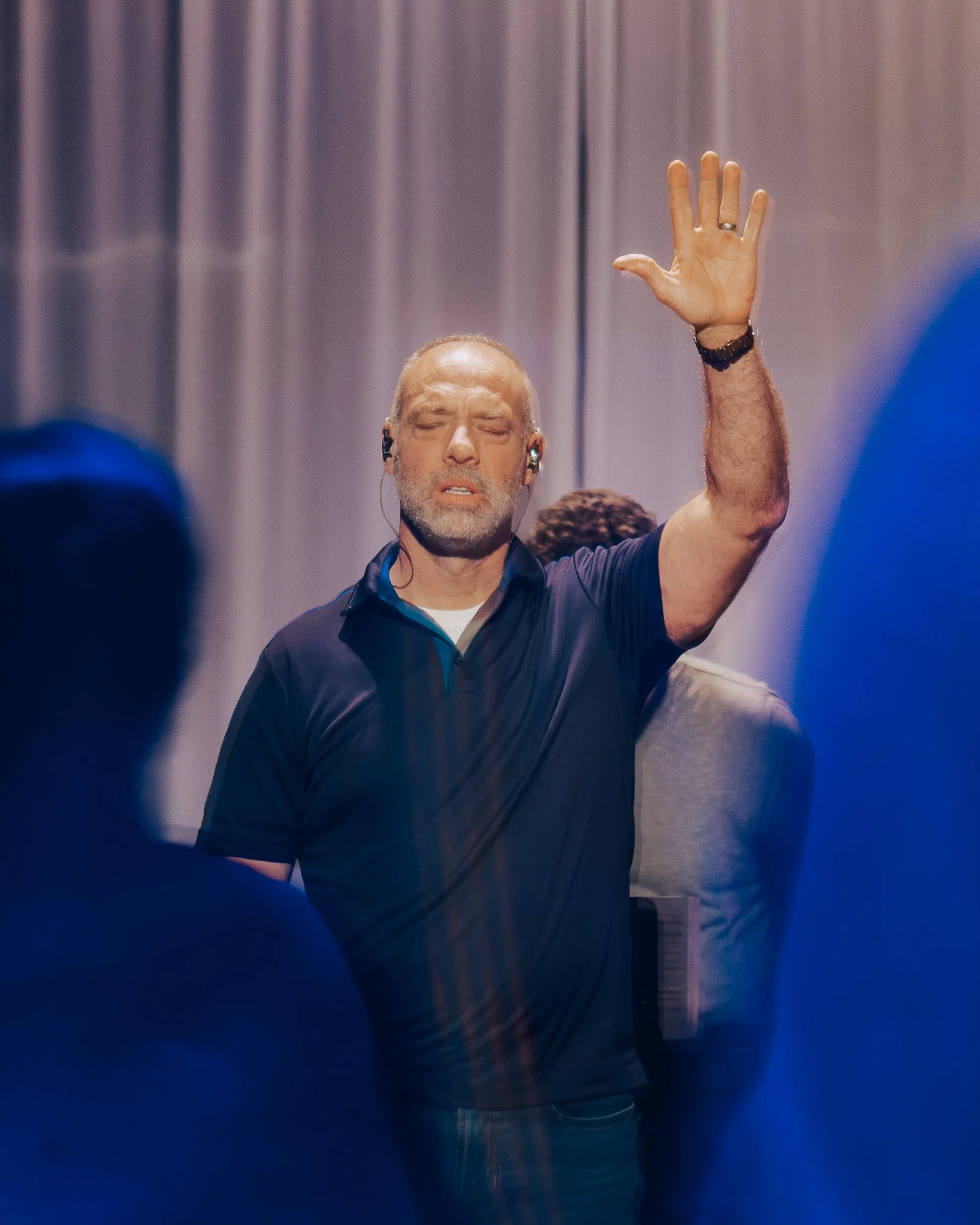 A worshipper raising his hand during a New Life Church gathering