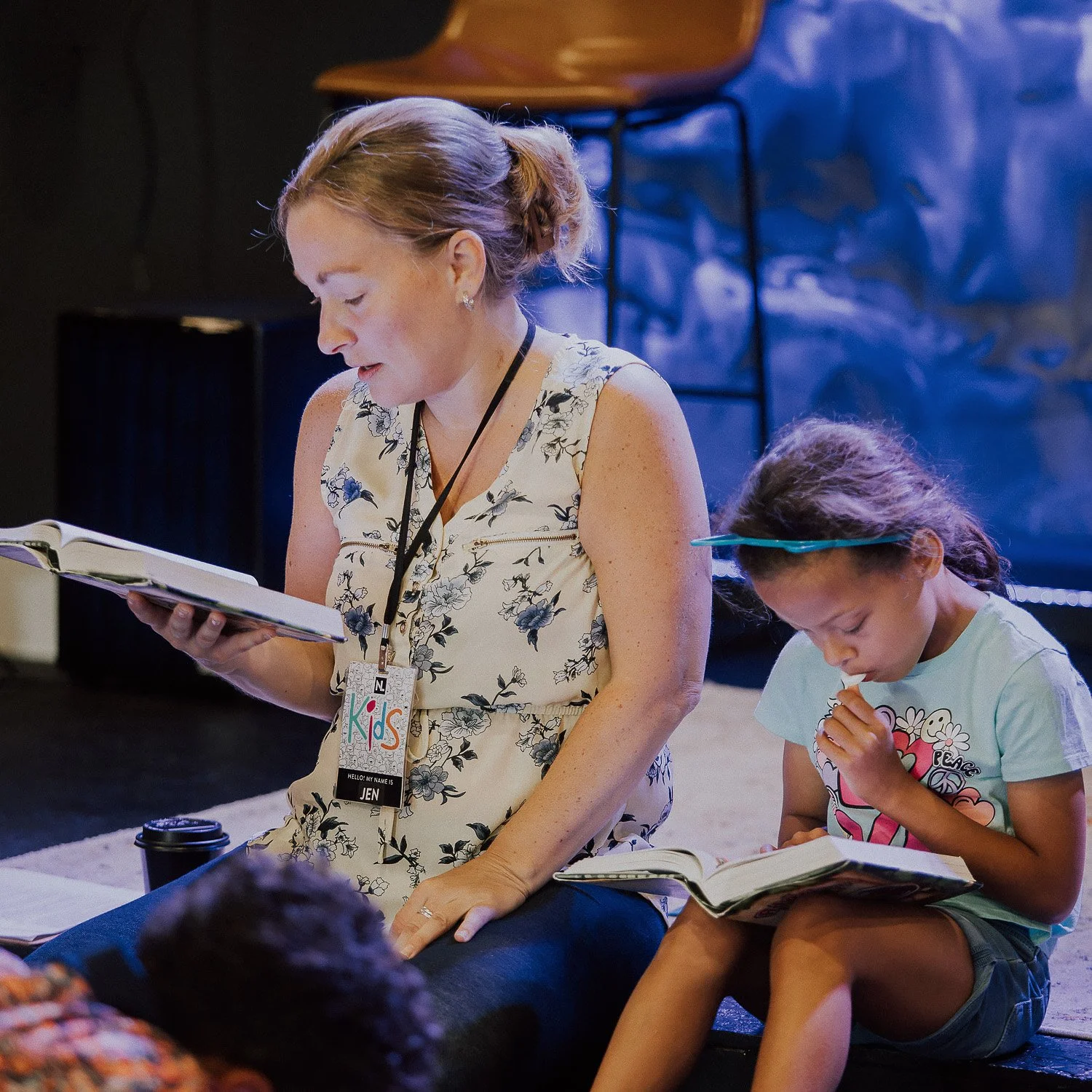 A New Life Kids leader reading the Bible with a child during a Sunday service