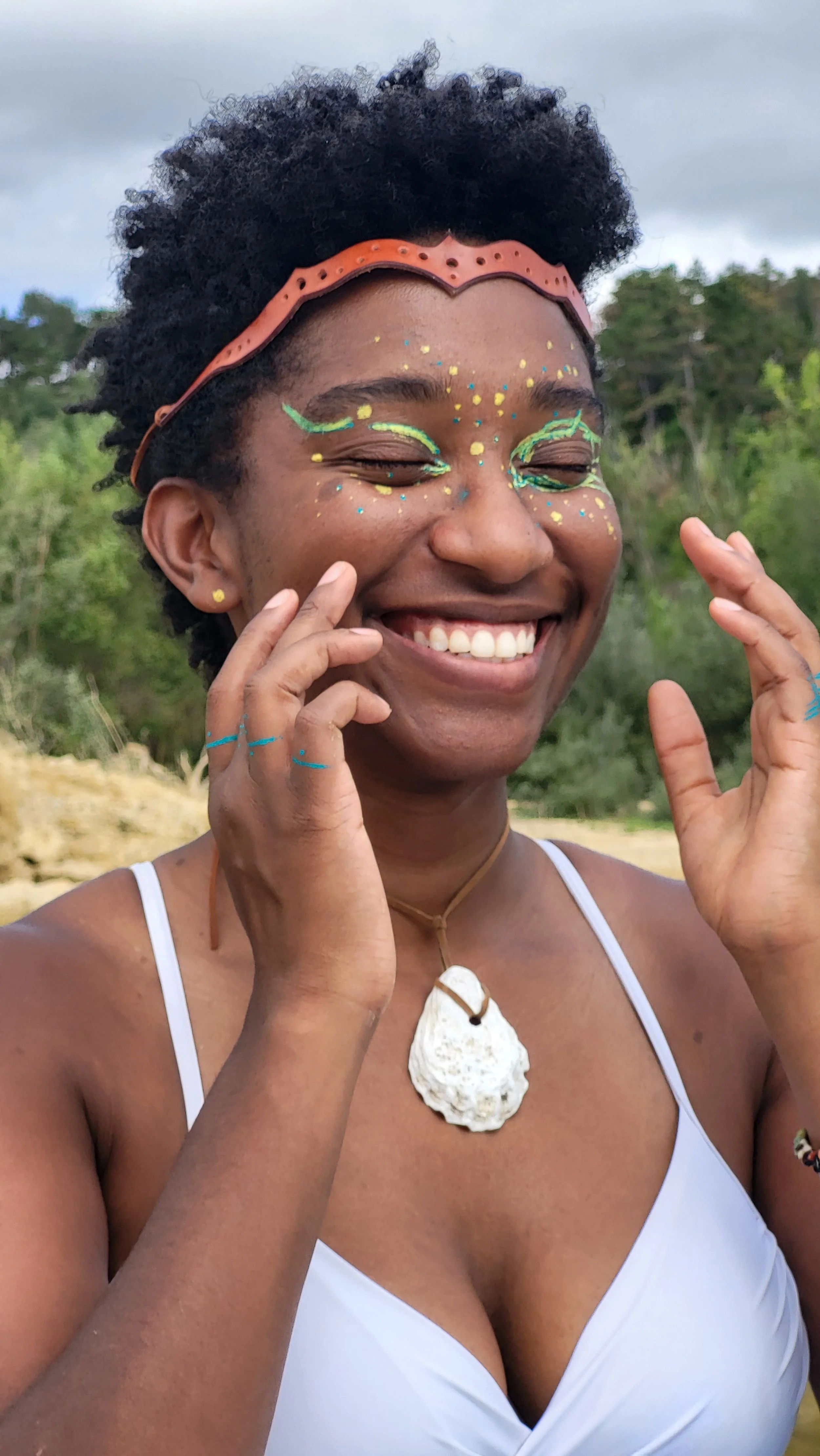 Mermaid Andrina as a Wild Water Goddess smiling with fingers to cheeks