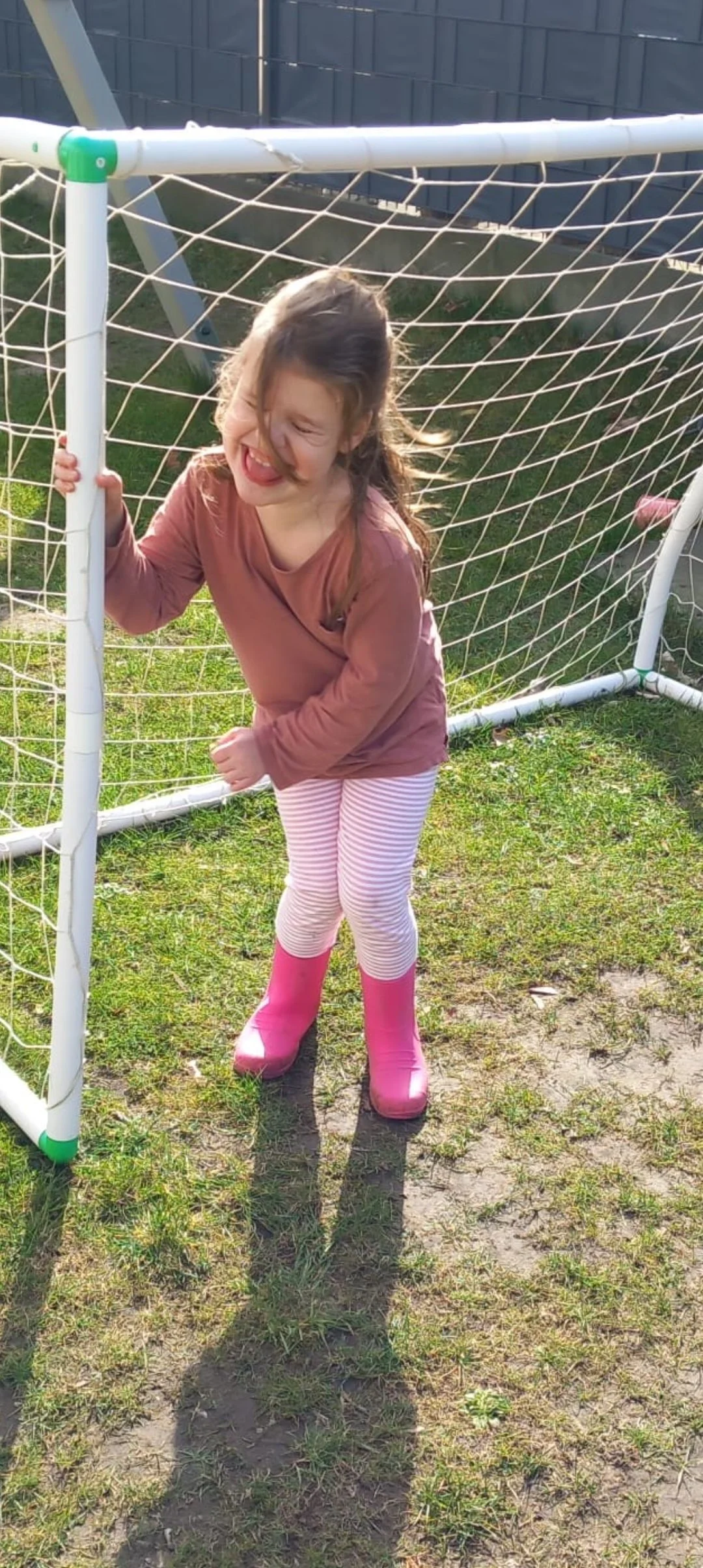 Ein lachendes Kind steht voller Freude im Fußballtor und entdeckt spielerisch seine Balance und Mobilität im Raum Minden.