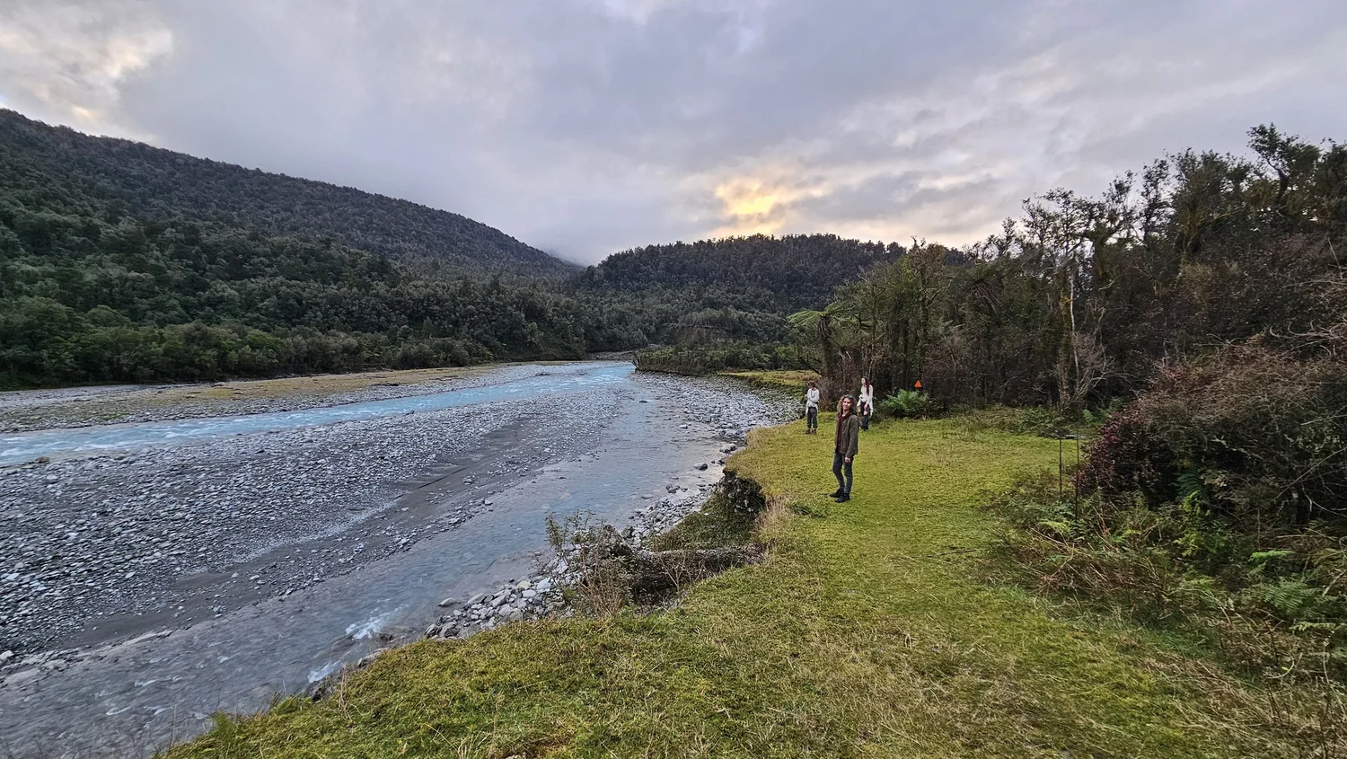 Our family beside the Arahura River with an orange triangle track marker