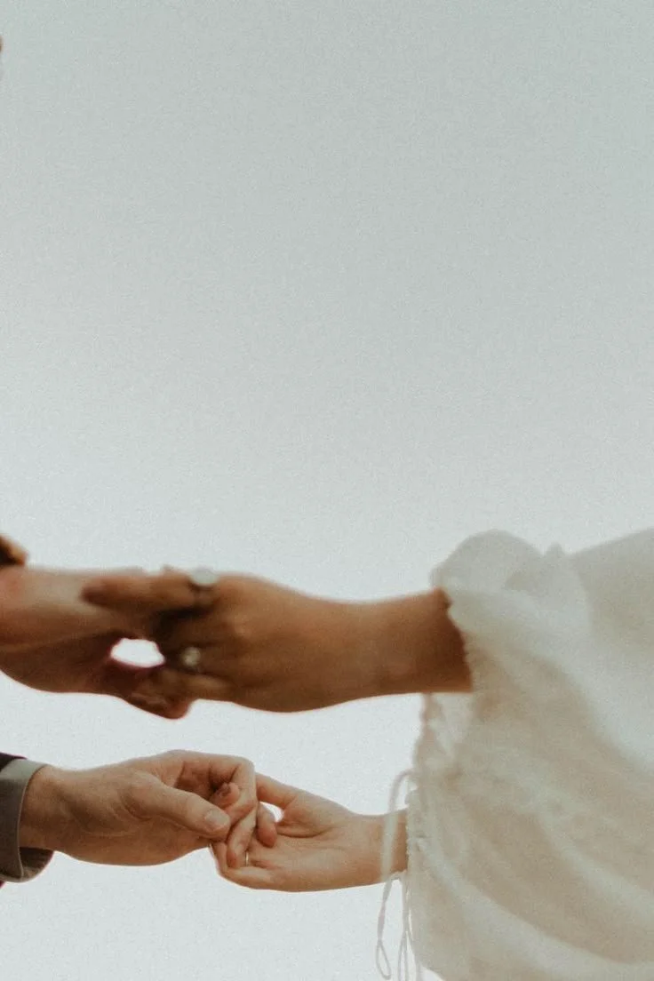 Close-up of two people holding hands, one person helping the other to stand or steady themselves.