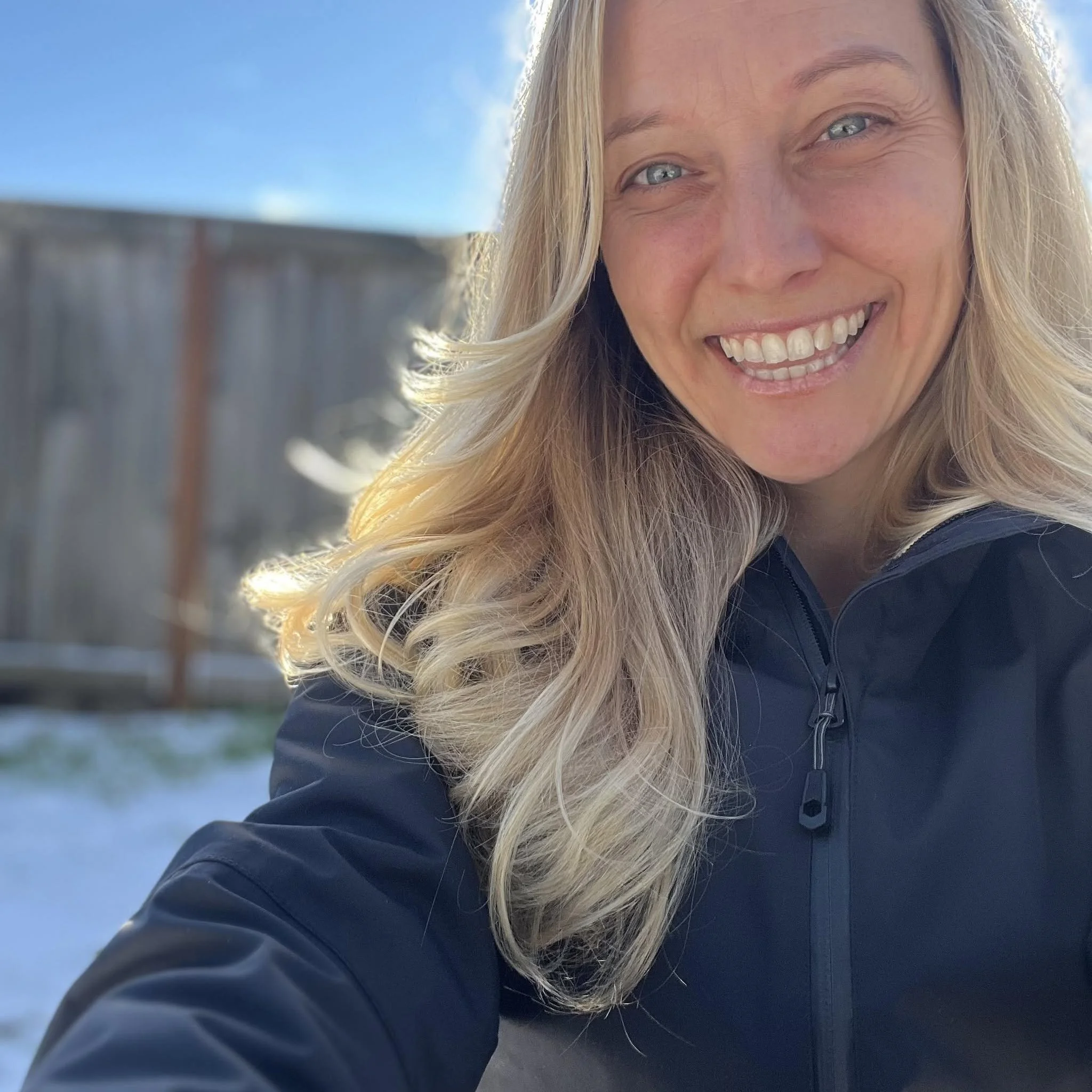 Sarah Hedal smiling outdoors under a blue sky.