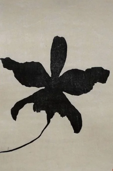 A black silhouette of a leaf or plant with a long stem on a light background.