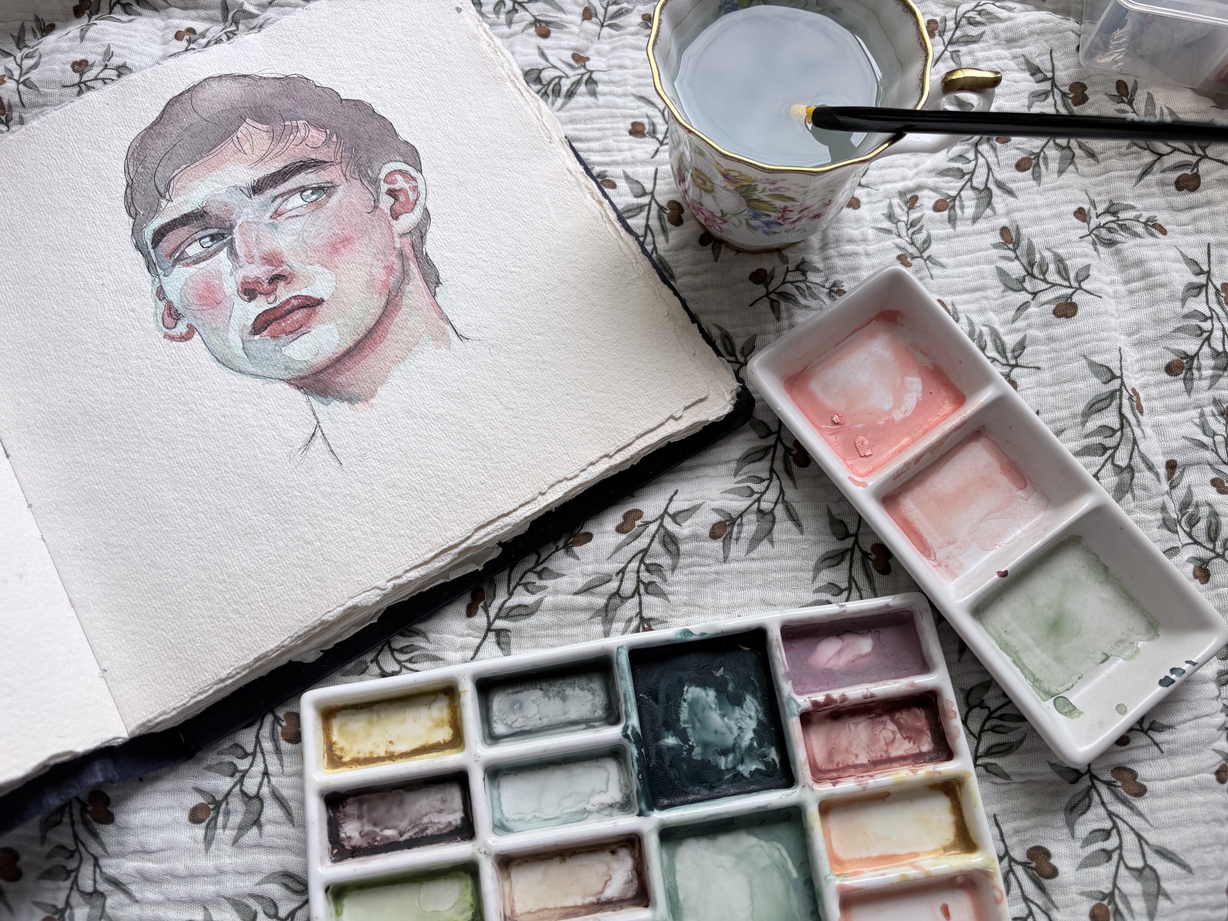 watercolour paints and painting of a man's face