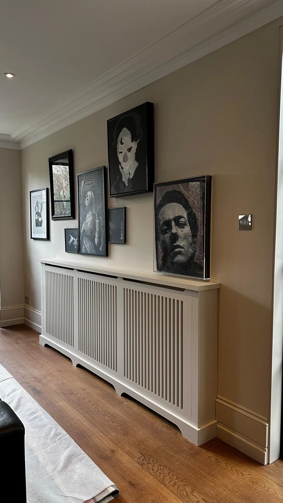 Professional residential paint job featuring warm beige walls and matching painted slatted radiator cover for a seamless finish.
