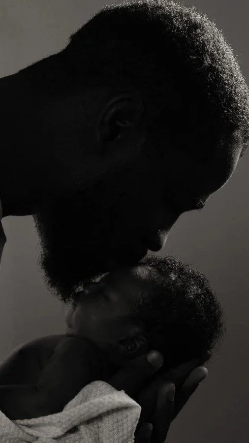 Father holding a newborn baby close to his chest