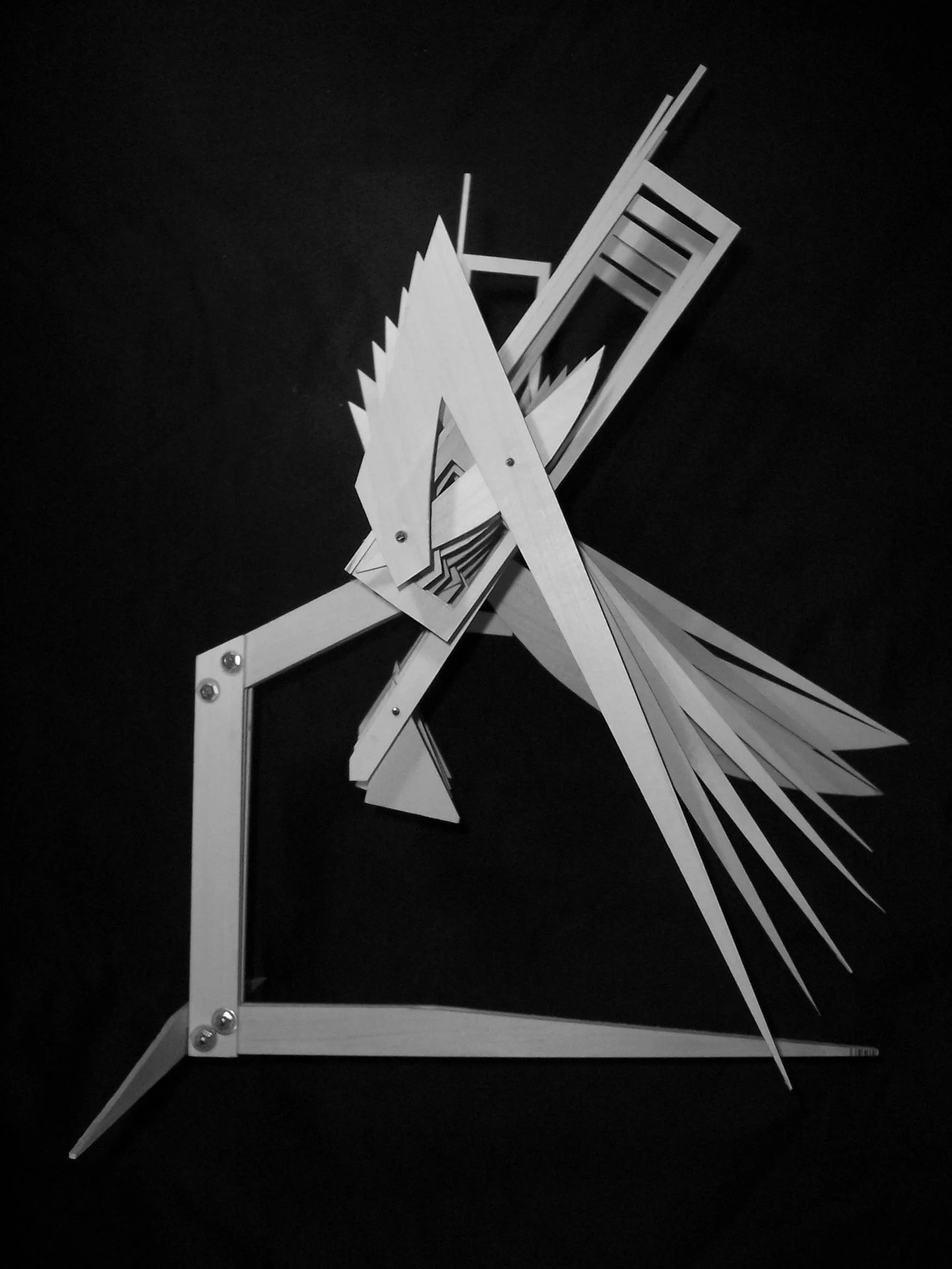Black and white image of a decorative rooster made from geometric wooden pieces, mounted on a black background.