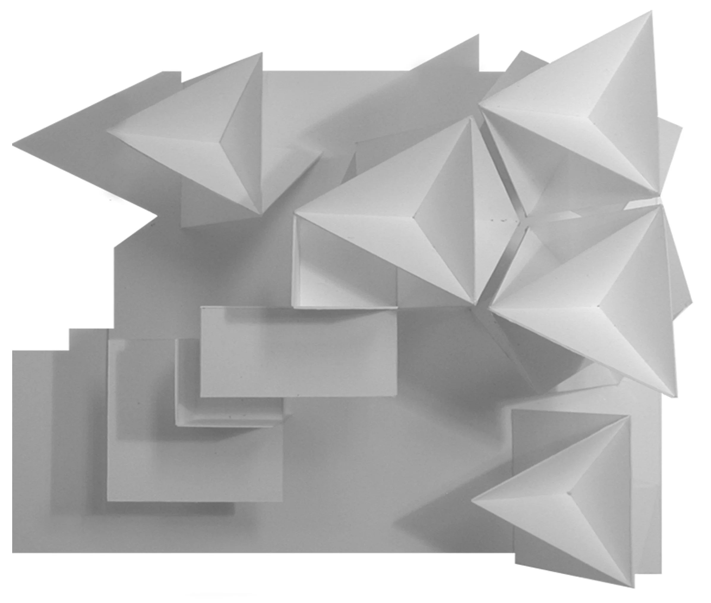 A geometric, abstract sculpture with sharp, angular planes, made of a white or light-colored material.