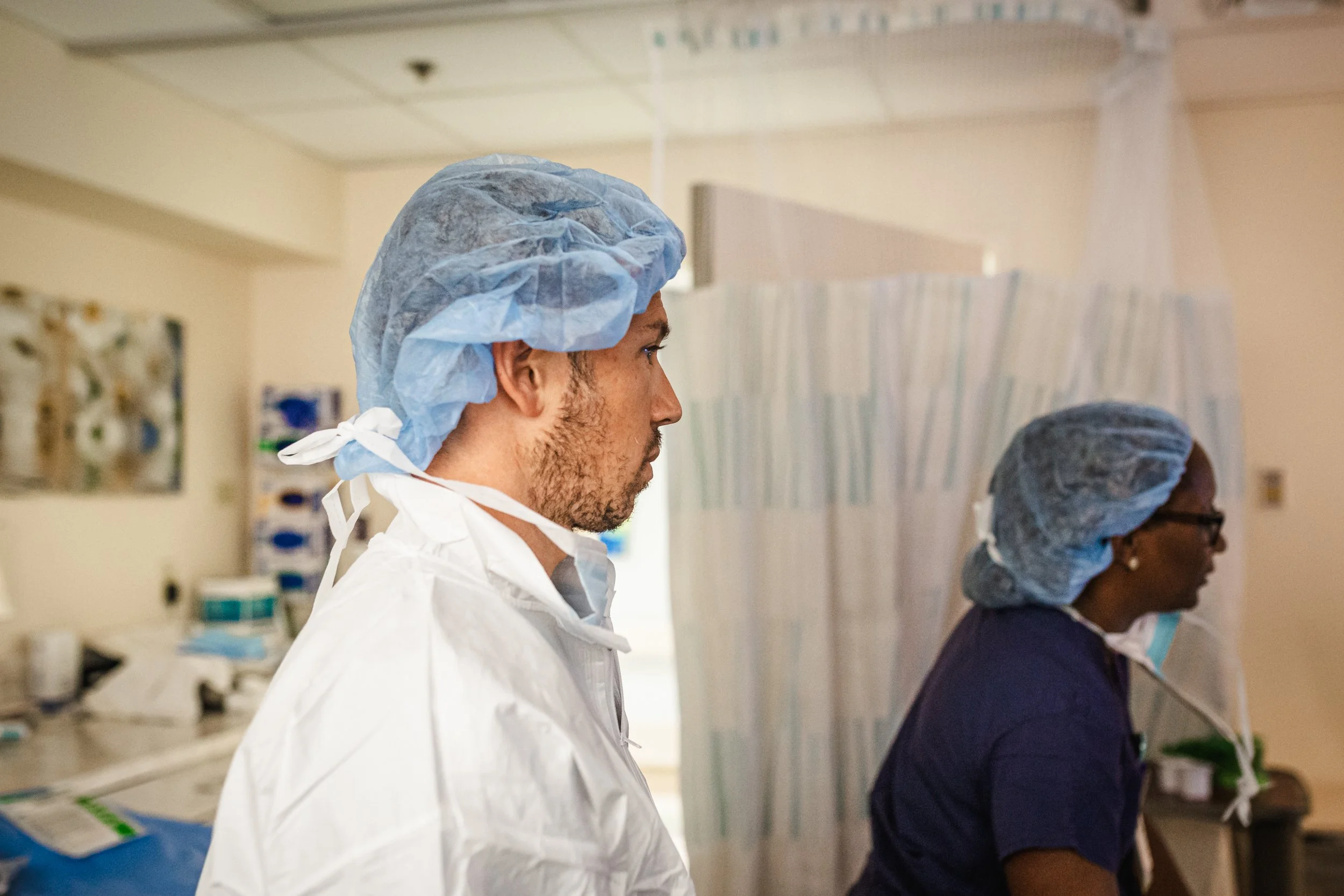 Healthcare workers wearing protective gear attending to patients in a medical facility