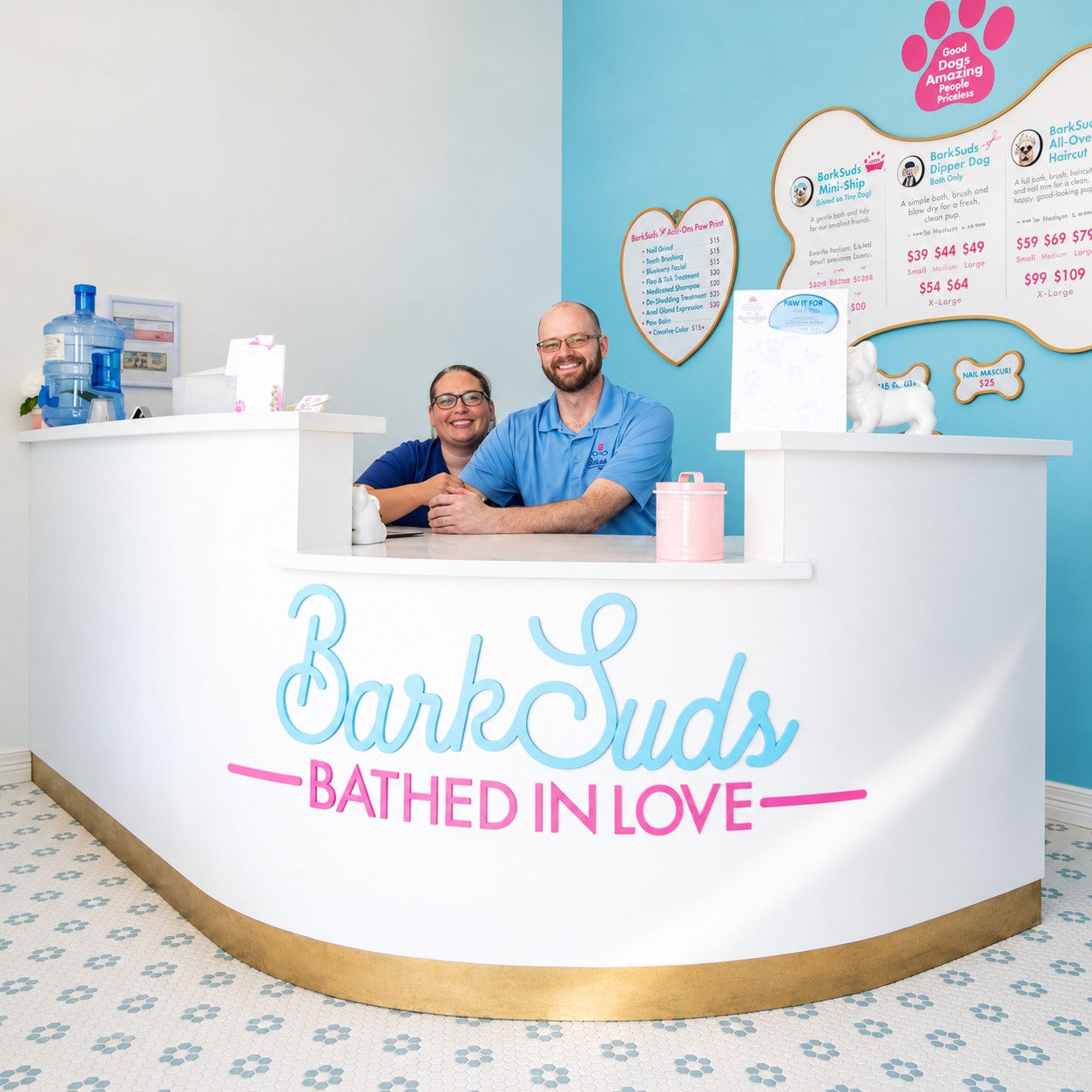 Dabrina and Nathan behind the reception desk at BarkSuds Sugar Land